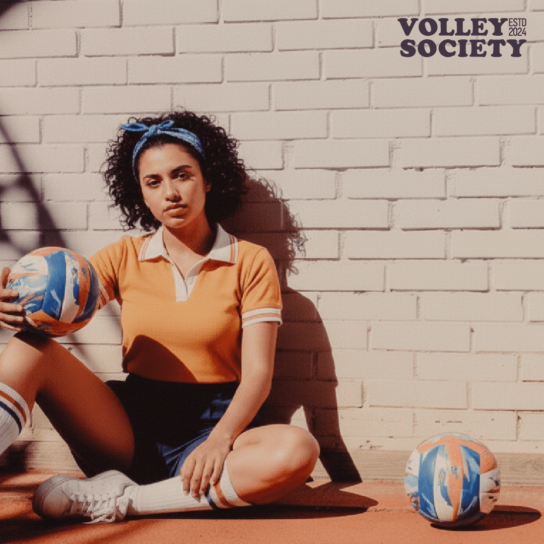 A close-up of a hand wearing multiple decorative rings against a blue background.