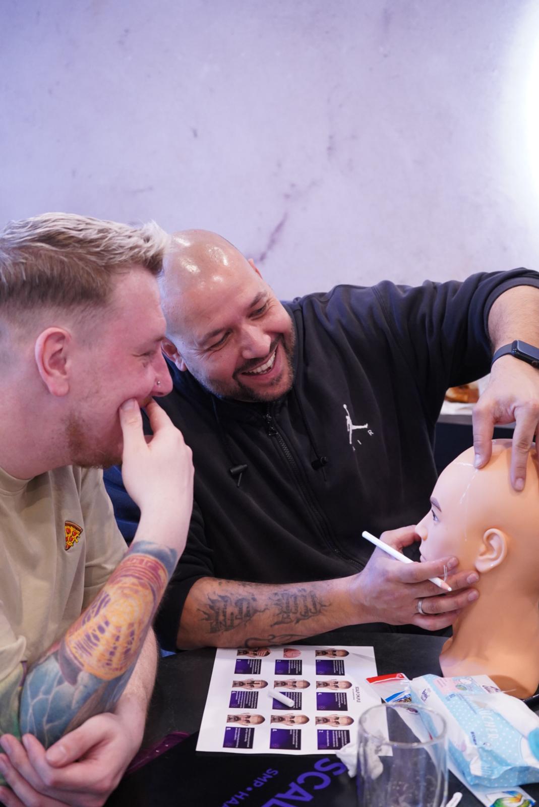 Igor Mahovlic gibt einem Kursteilnehmer persönliches Feedback bei der SMP Übung am Trainingskopf – praxisnahe Ausbildung bei Scalp Couple