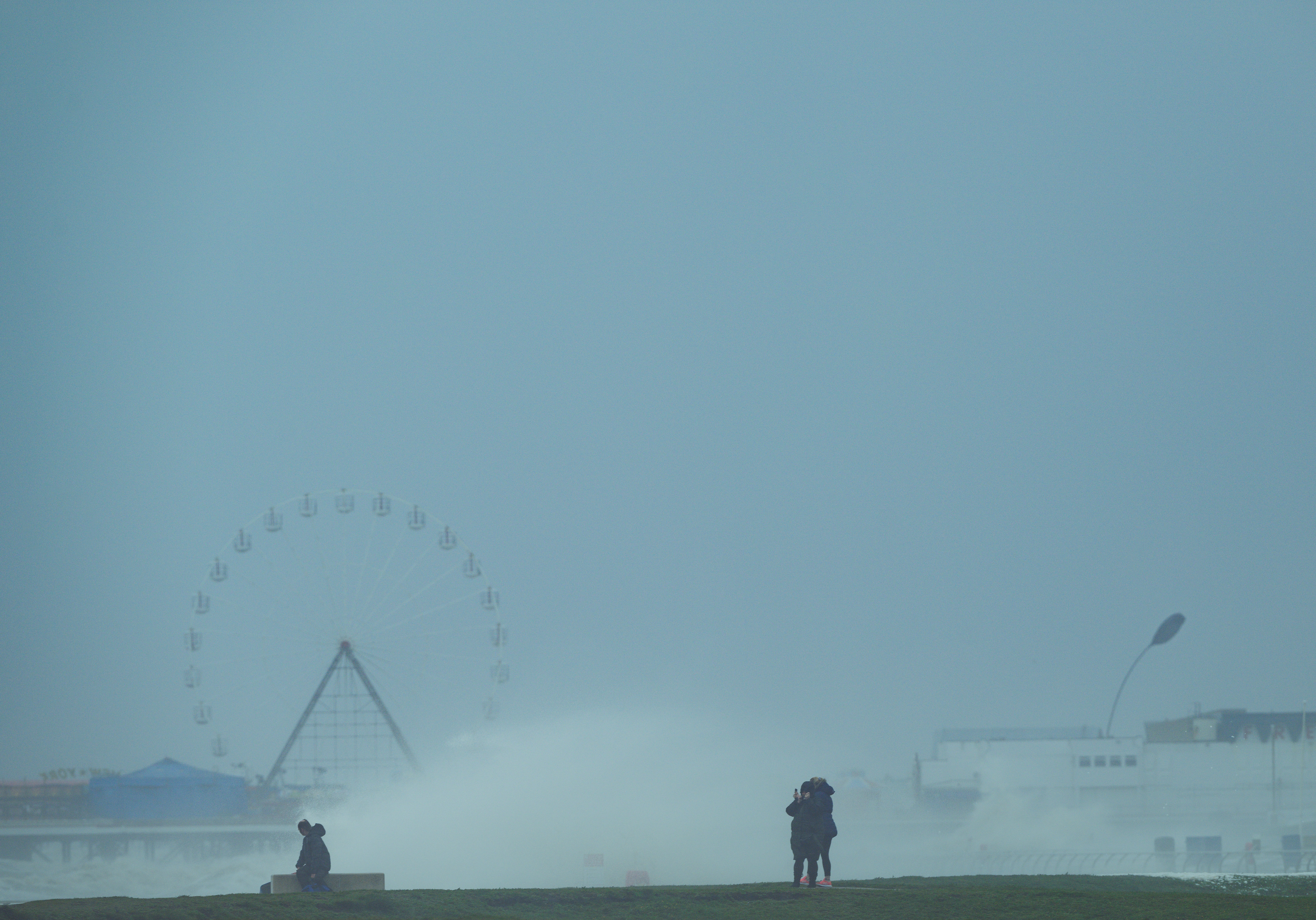a couple of people standing on top of a grass covered field