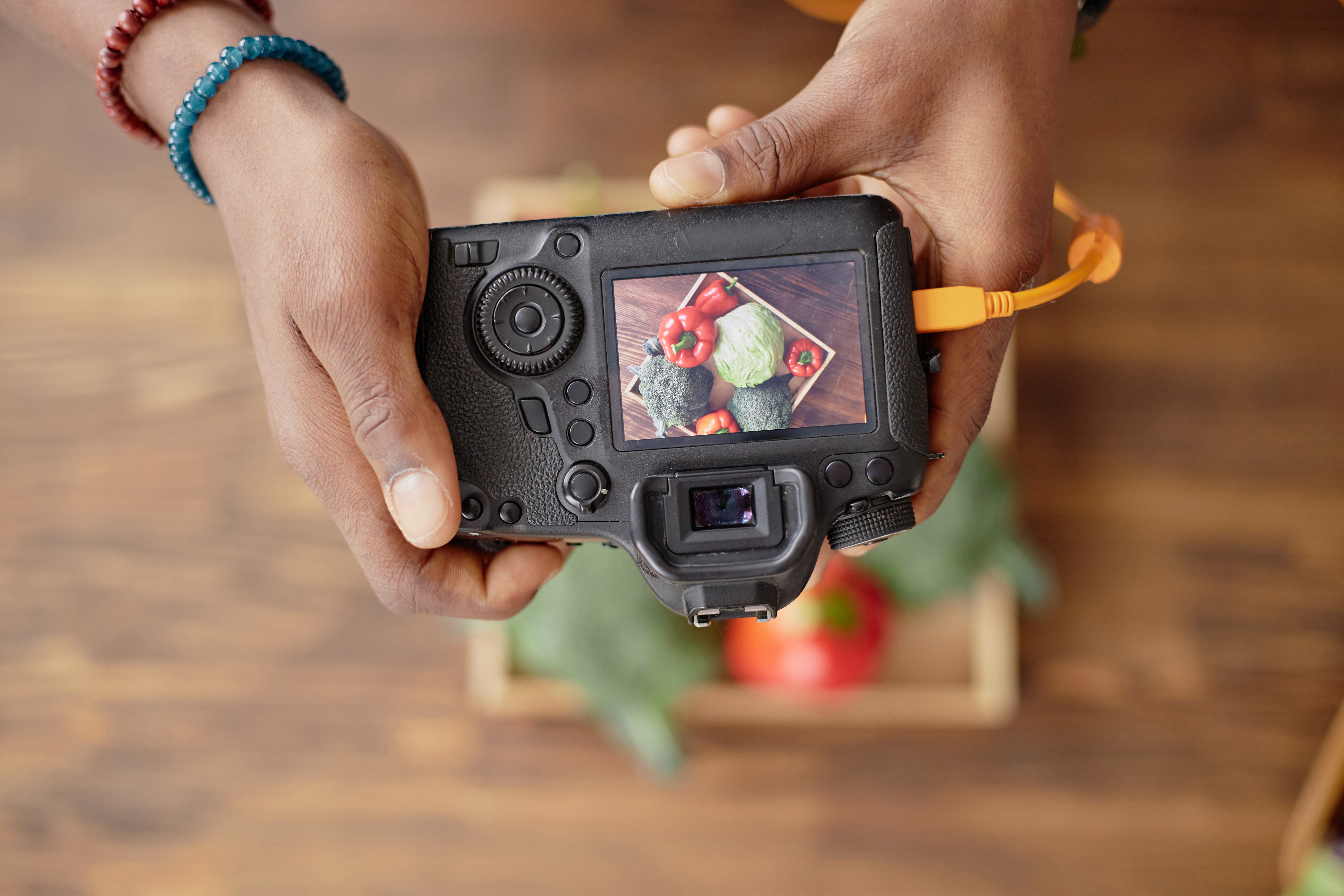 Black and white image of people working at a table with laptops, showing hands gesturing during discussion of digital content displayed on screens, with fabrica® logo in the corner.