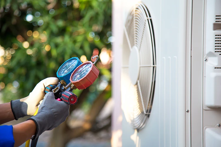 Blurred background image of an HVAC technician's hands carefully repairing the internal components of a heating unit.