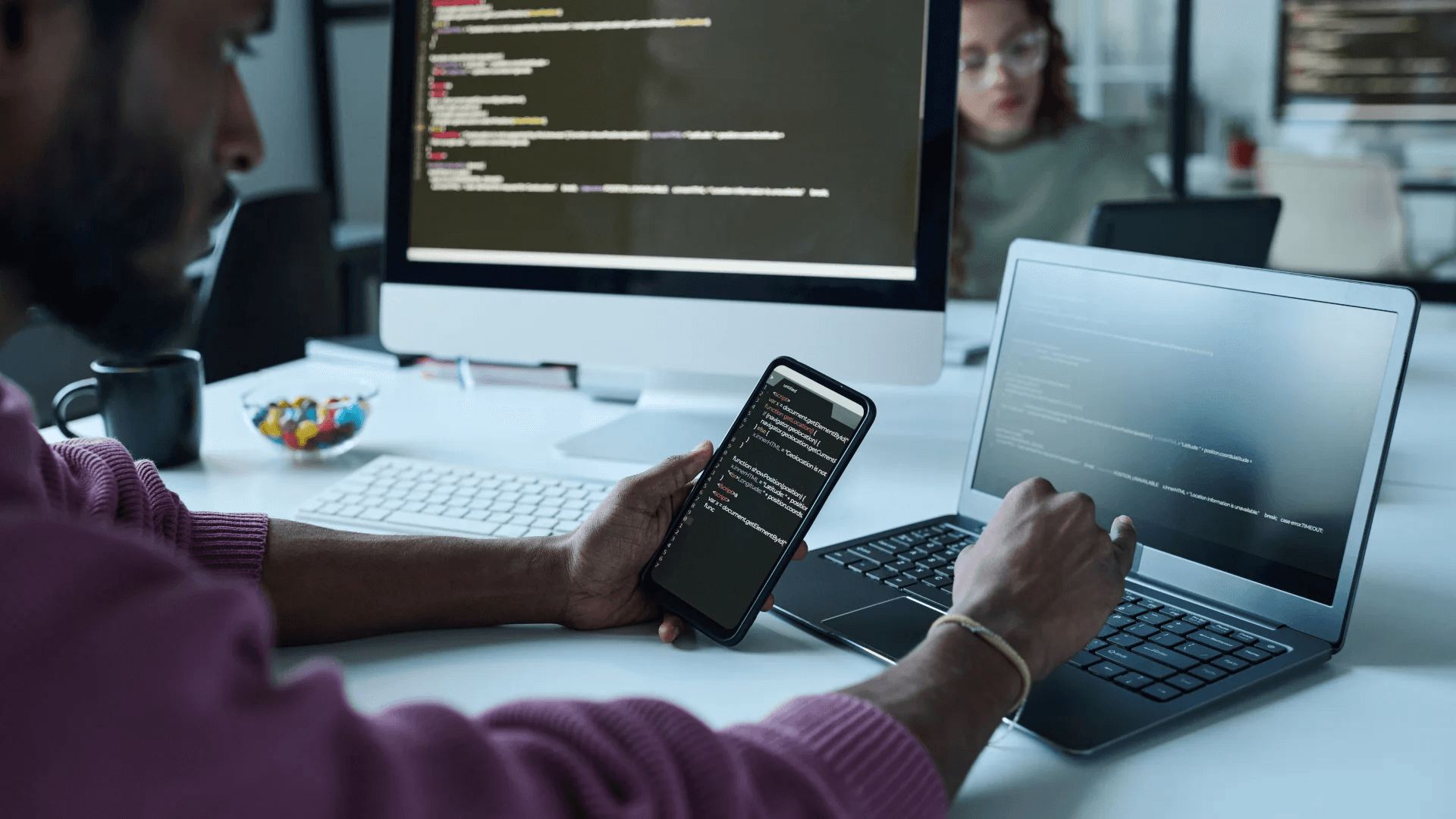 Programmer writing code on multiple devices - Best Place to Hire Mobile App Developers