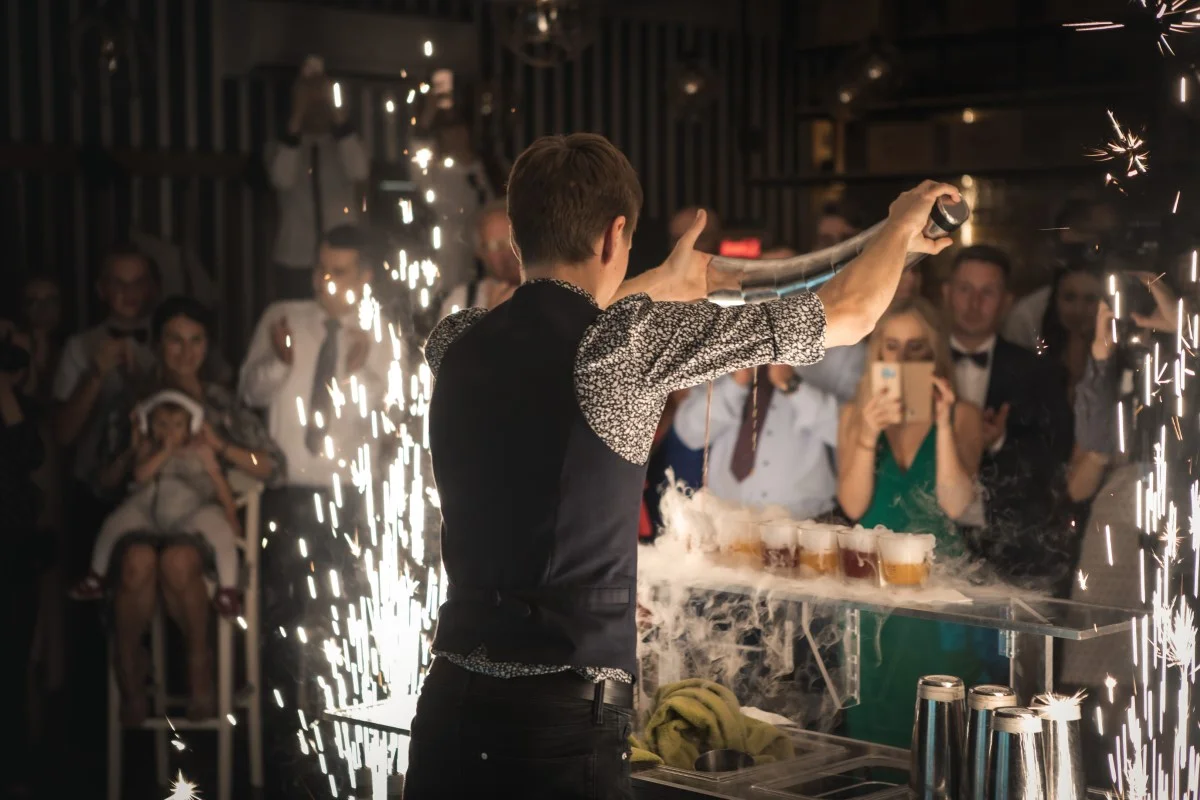 Drink bar na weselu z barmanem zachwycającym gości podczas pokazu.