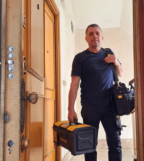 Titolare della S.A.Multiservizi Roma davanti appartamento con strumentazione tecnica e certificati