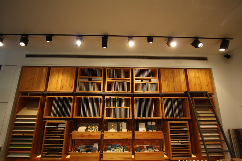 Wooden shelving wall holding tile sample books