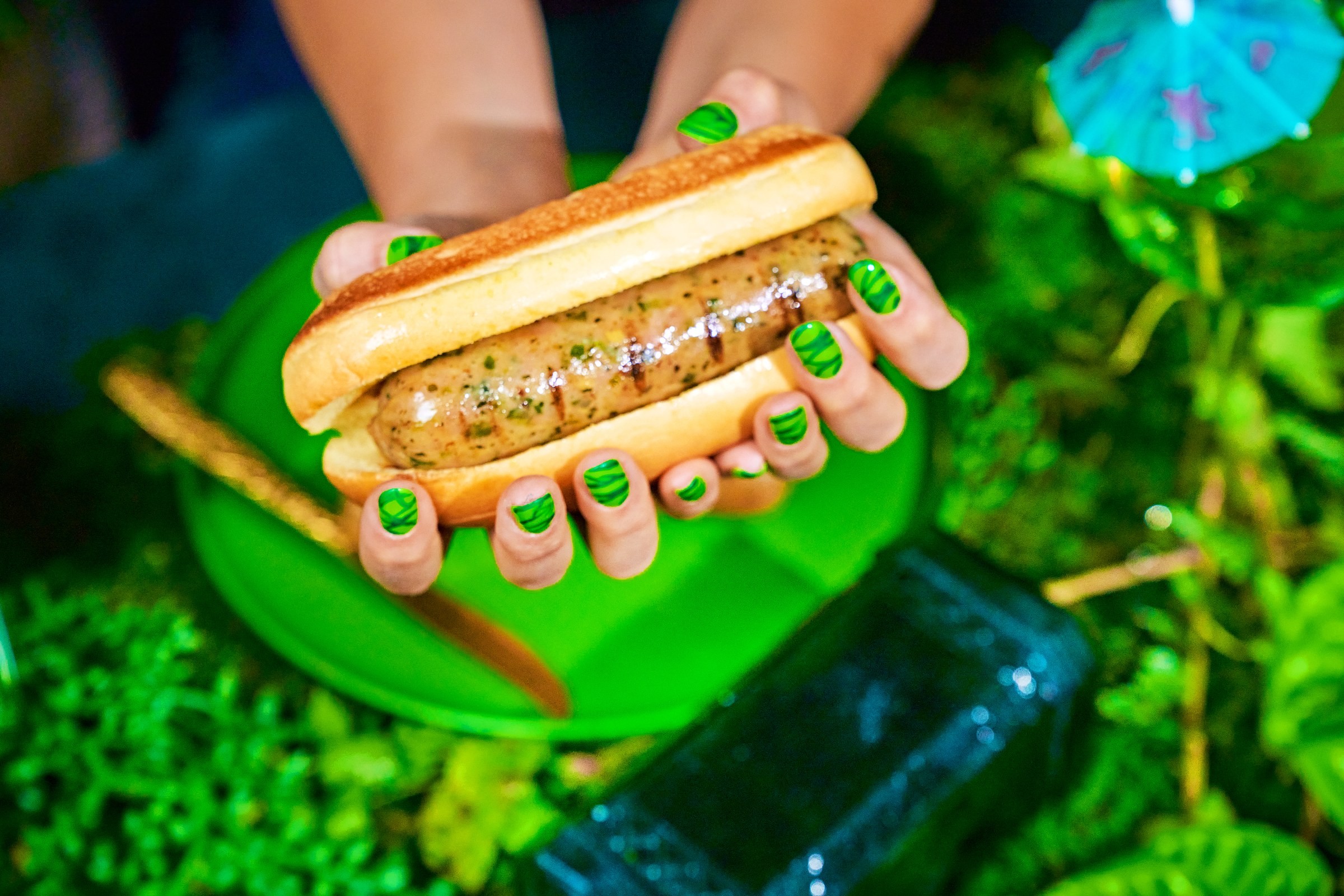 Close-up of a Salsa Verde sausage sandwich with green nails