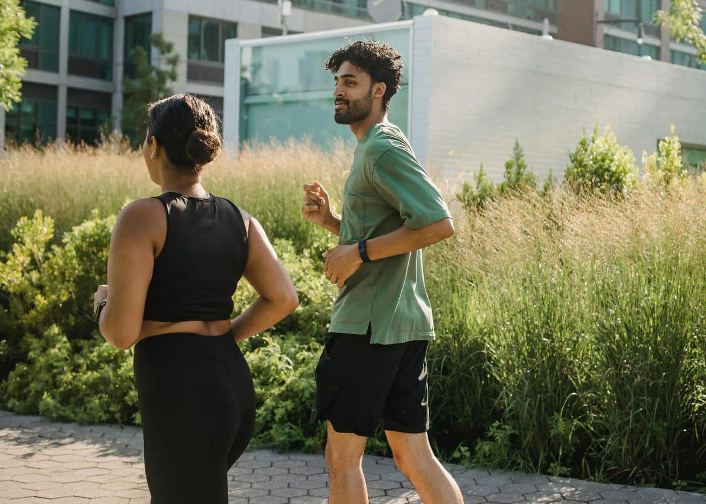 Man and woman jogging while wearing WHOOP bands