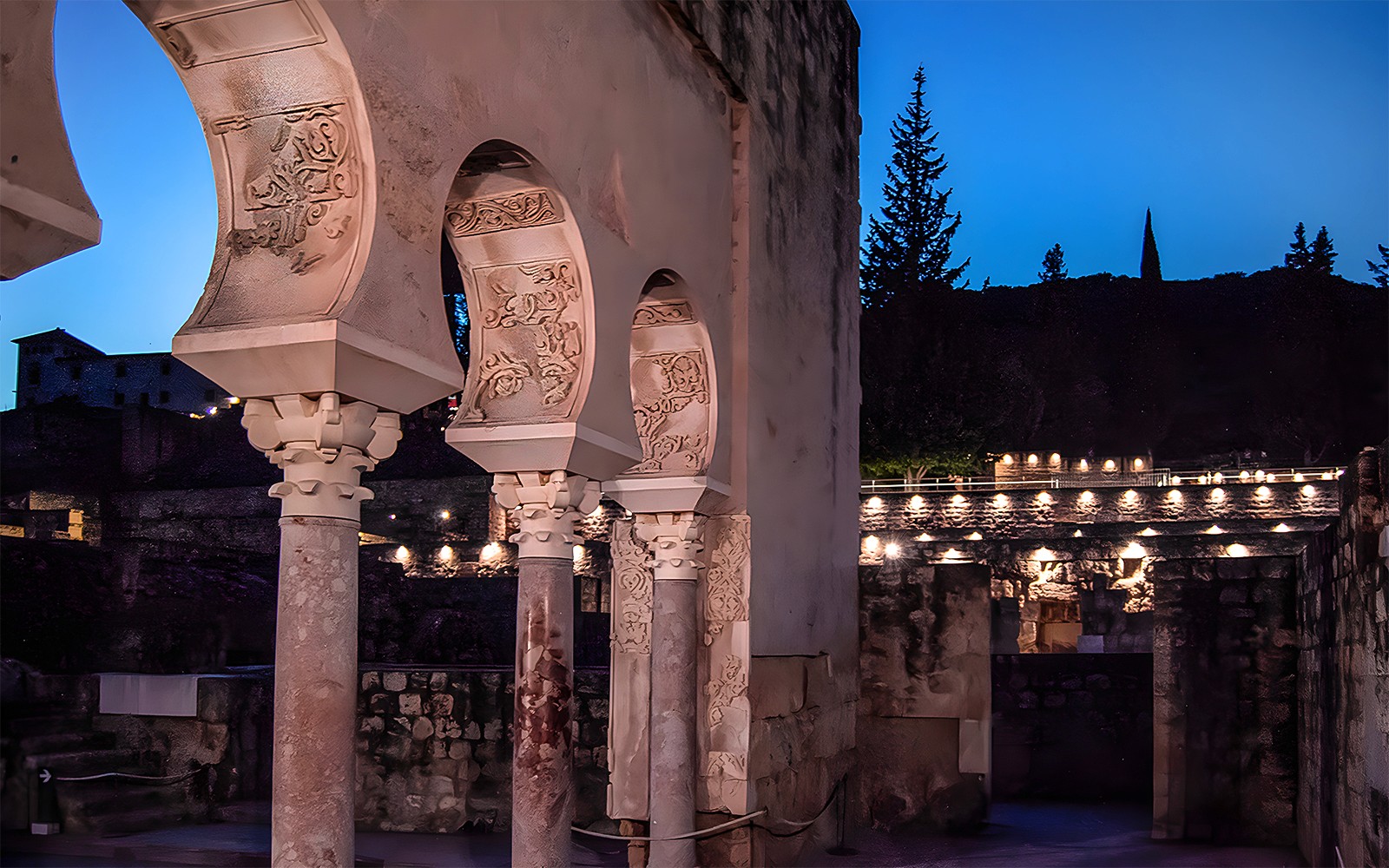 Arched columns illuminated at night in Medina Azahara, Córdoba.