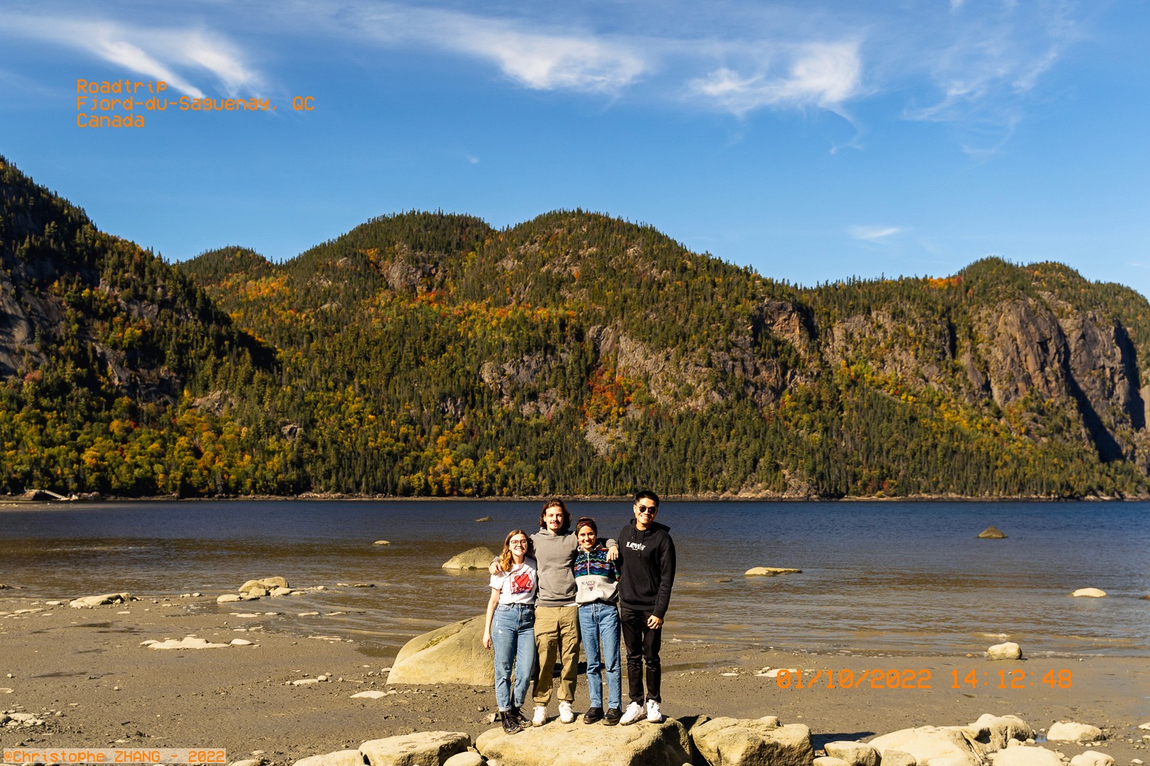 Photo de groupe avec le fjord du Saguenay en arrière-plan, sous un ciel bleu clair.