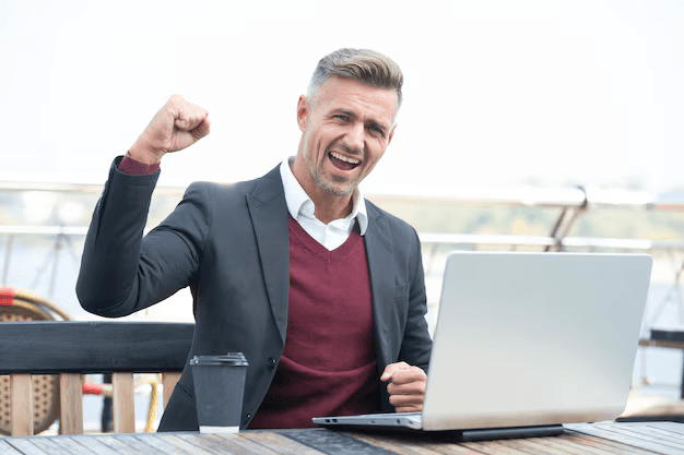 Woman working on a laptop computer at a table in a bright room.
