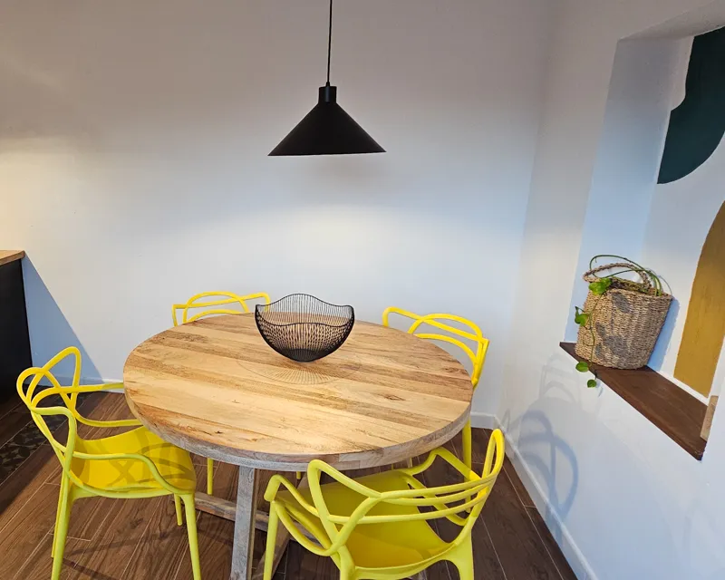 Stylischer runder Holztisch mit gelben Stühlen in La Terraza Tarifa