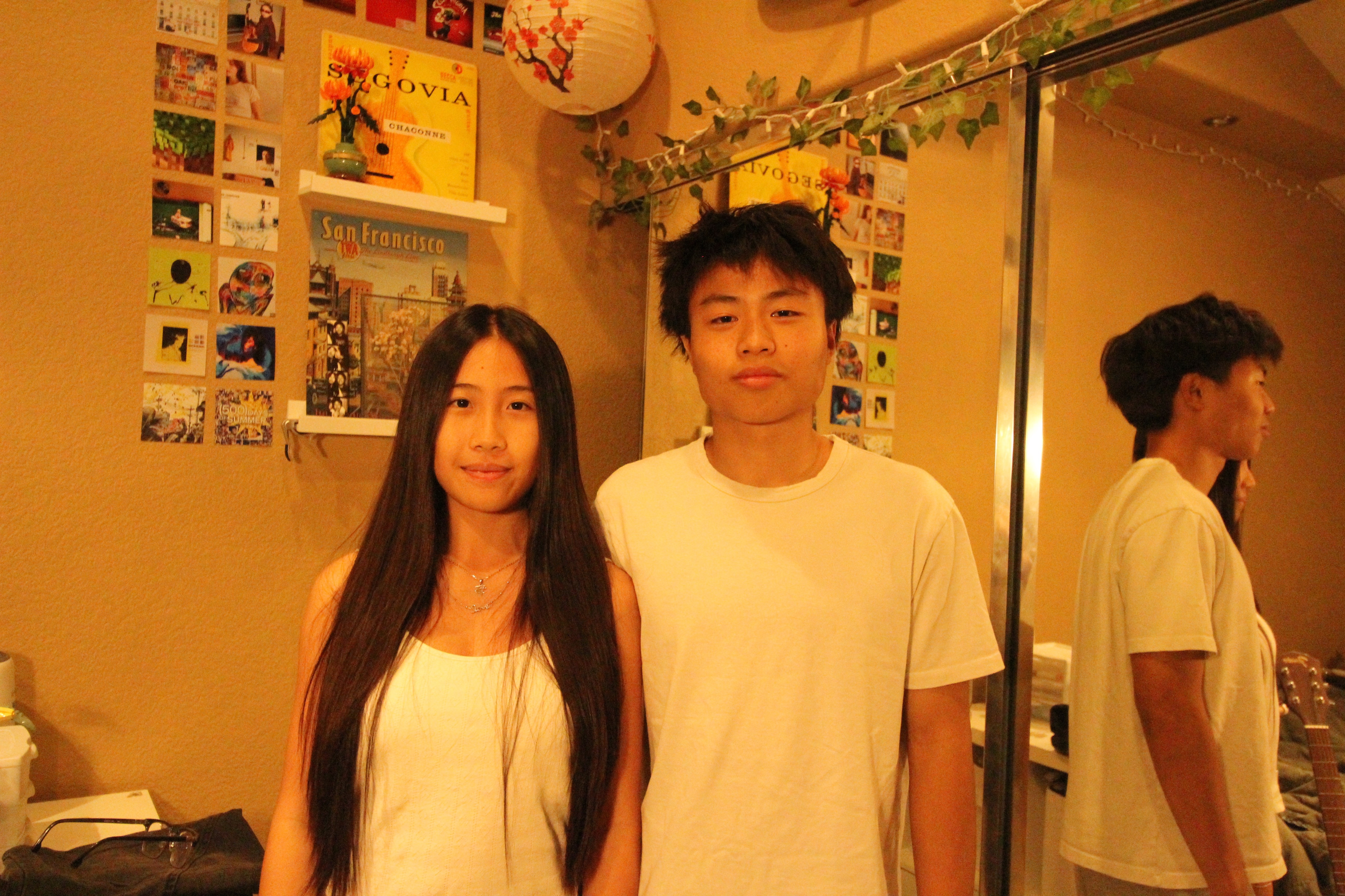 A group of six people poses on a city street, with buildings and shops visible in the background.