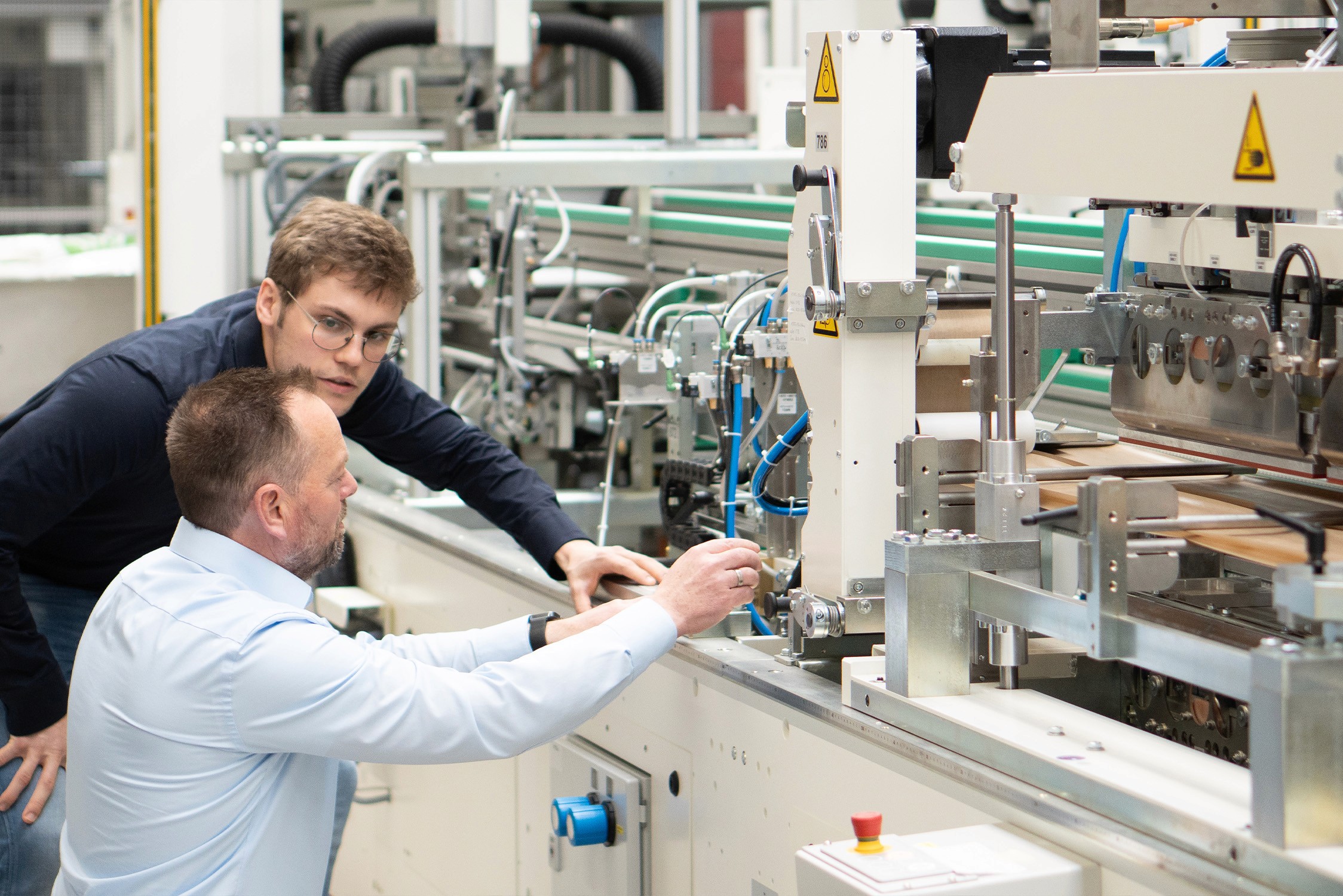 Zwei Männer arbeiten an einer Industrieroboter Maschine. Technik und Industrie.