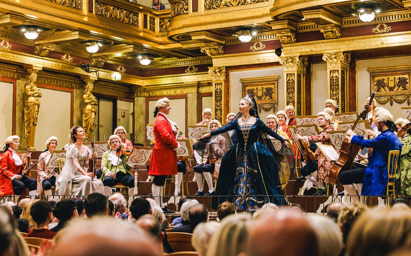 Mozart Orchestra performing in Vienna's Golden Hall with musicians in period costumes.