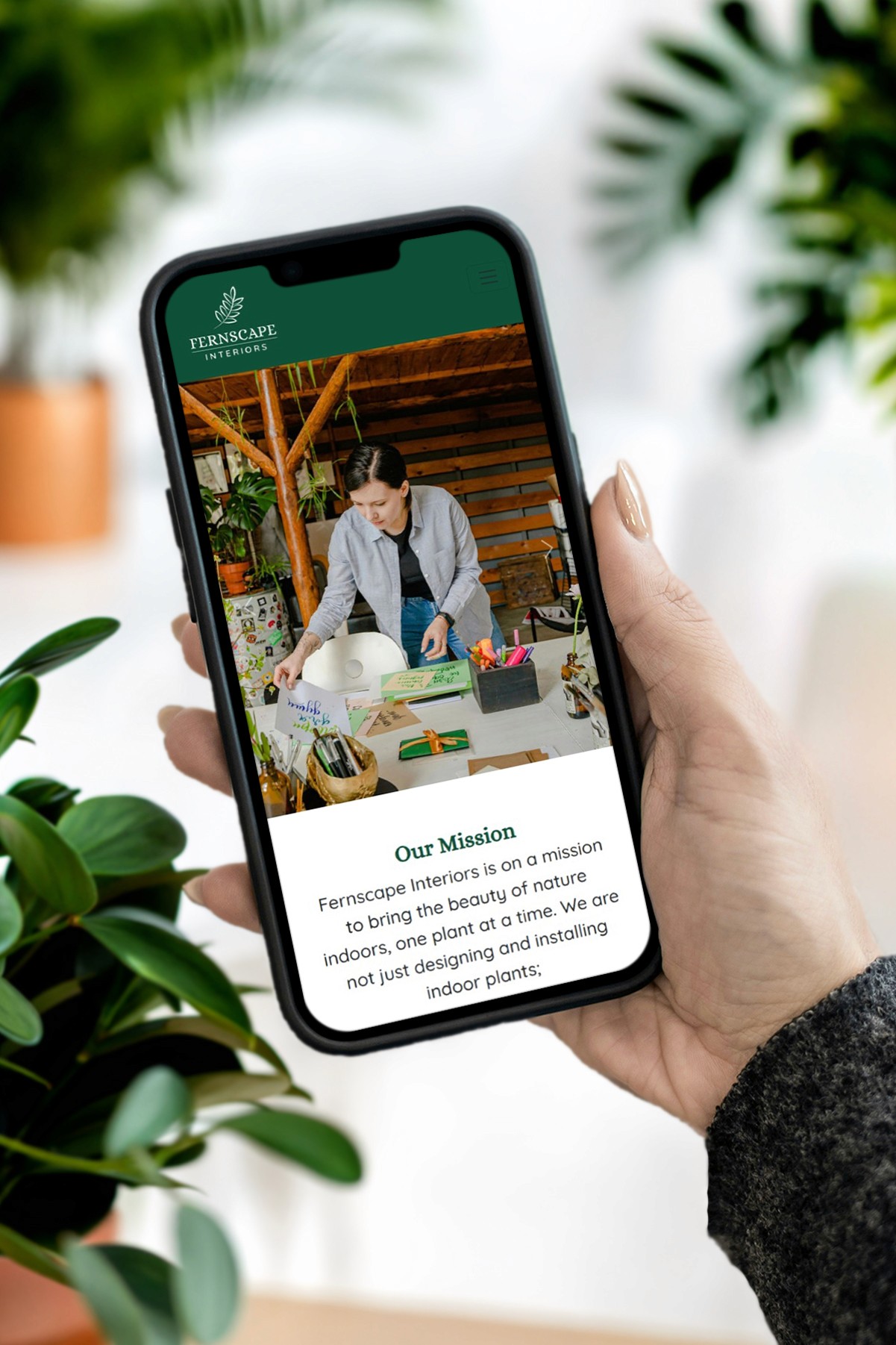 Woman holding phone with Fernscape landing page on screen