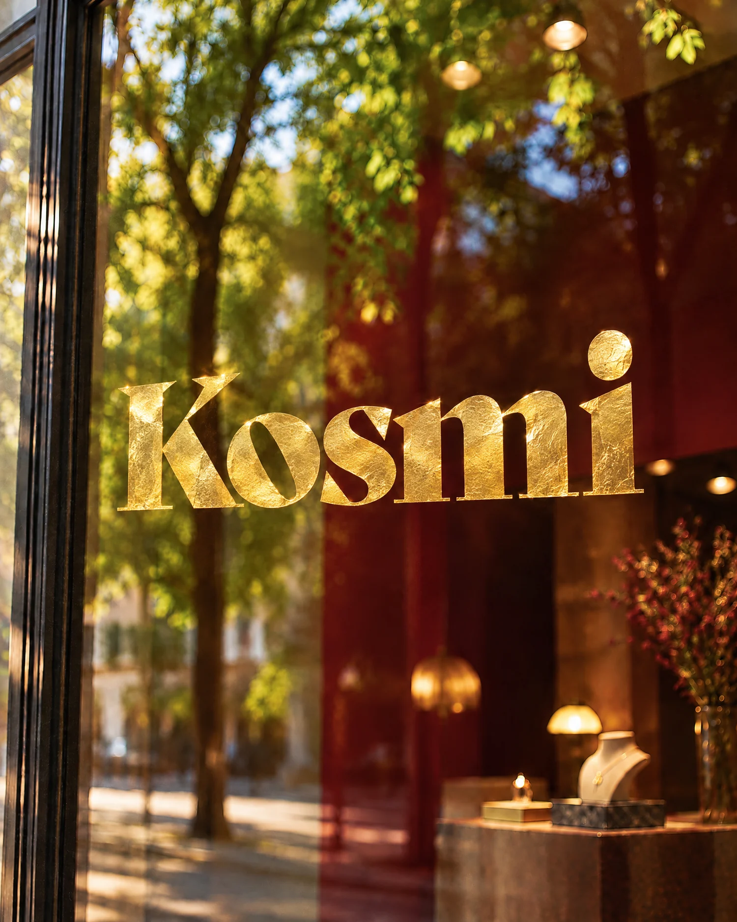 Kosmi logo in gold leaf on a boutique window.
