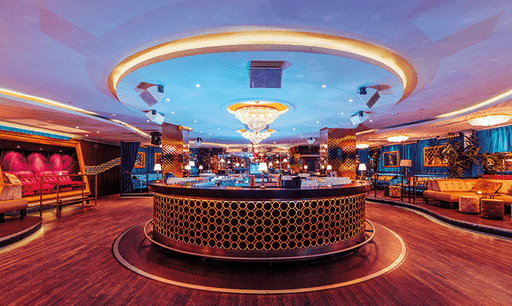 Two people installing or adjusting abstract blue artworks on a gallery wall