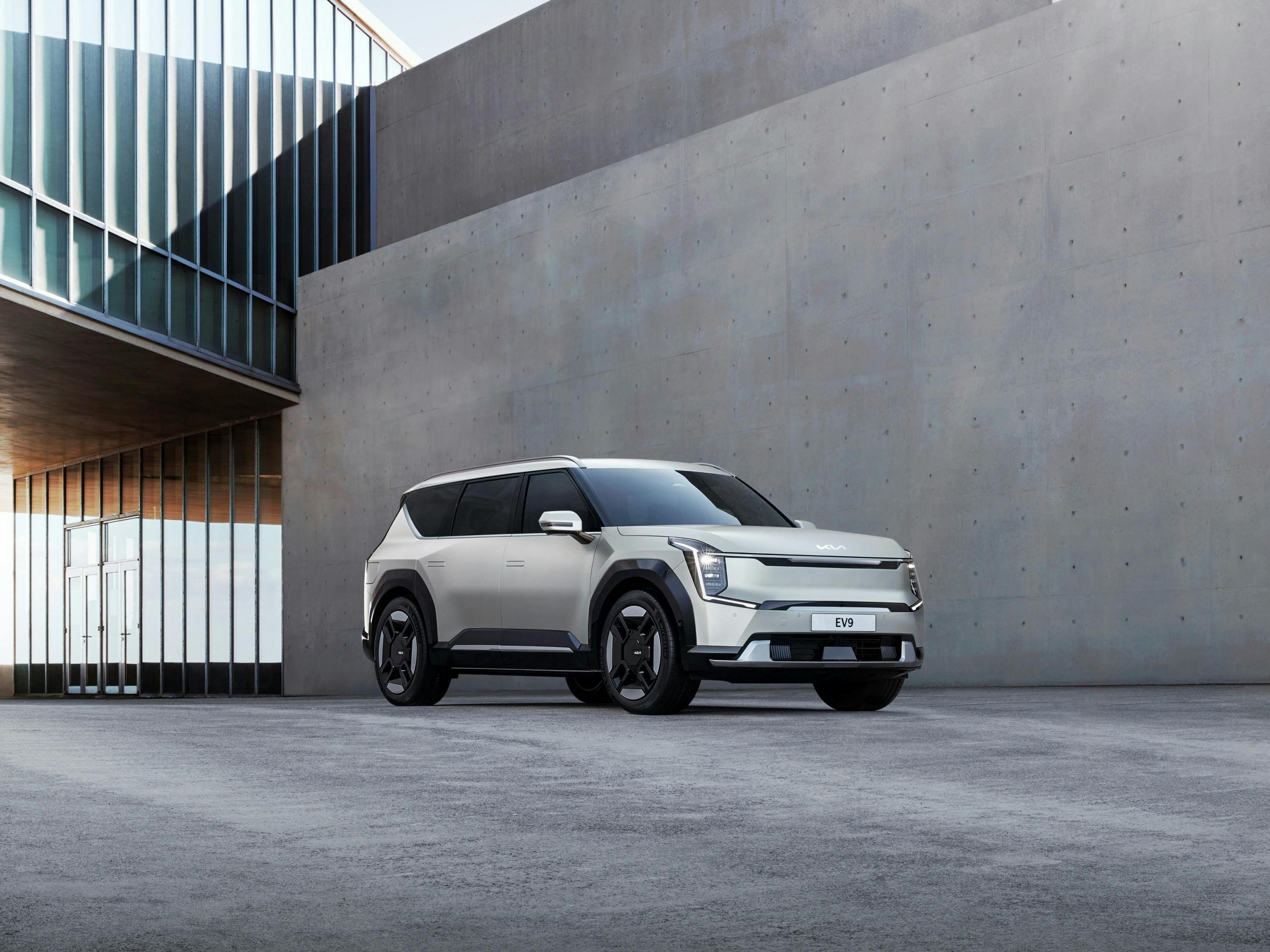Modern electric SUV parked near minimalist concrete building, contemporary automotive design