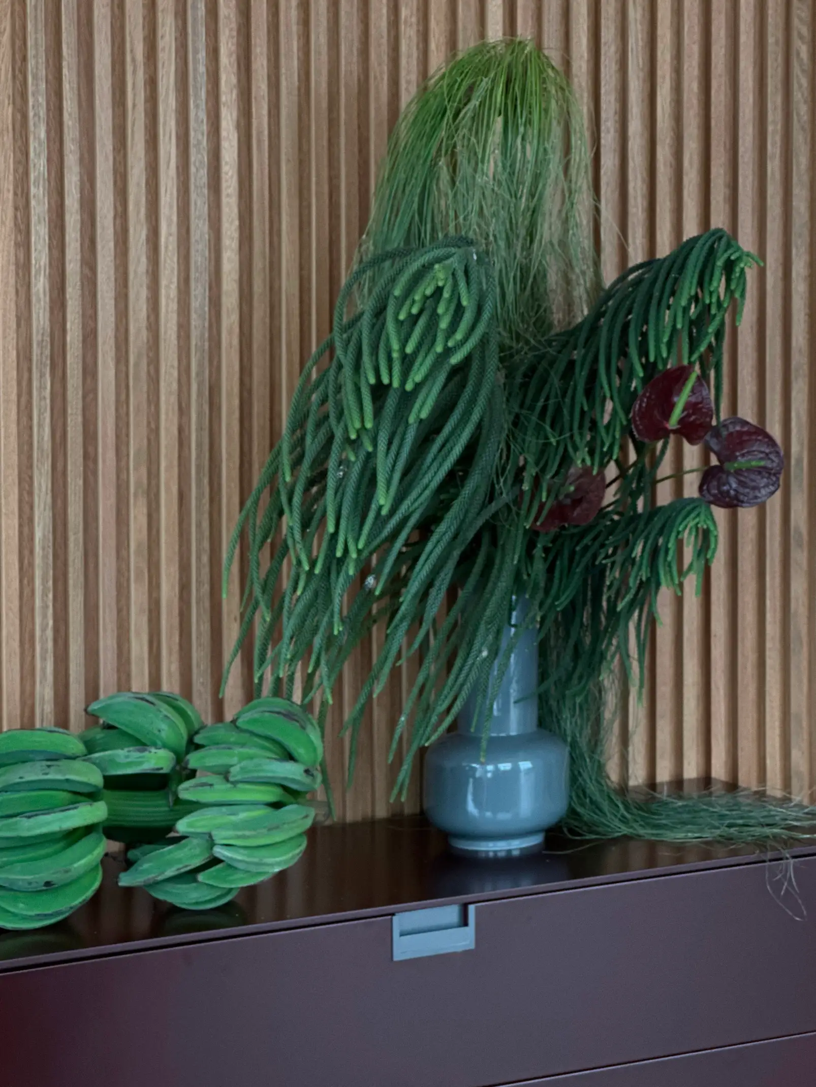 Instalación botánica con follaje verde y plátanos en interior de madera para marcas que comunican exotismo y naturalismo moderno.