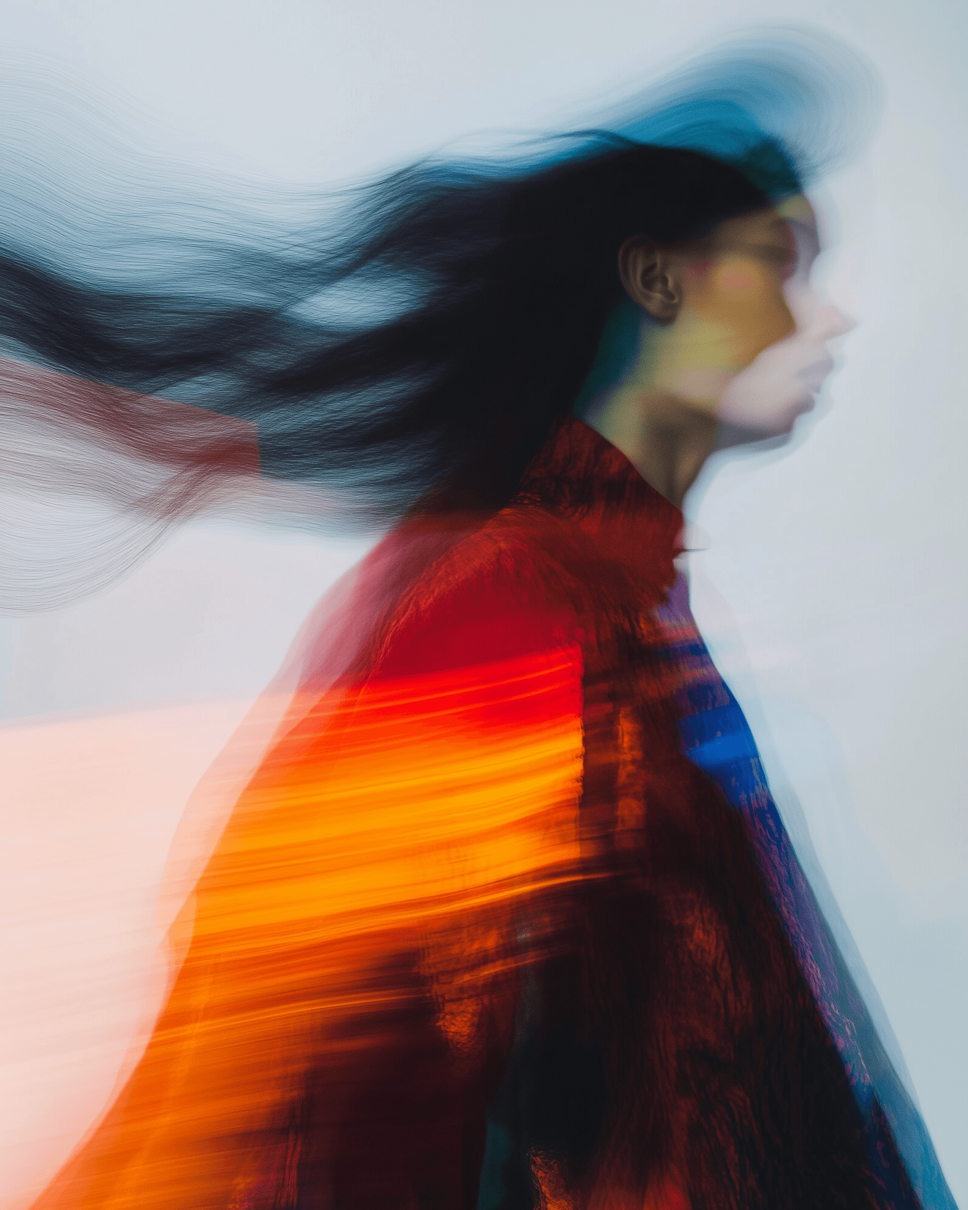 Performer in red captured in dynamic motion blur against a dark background.