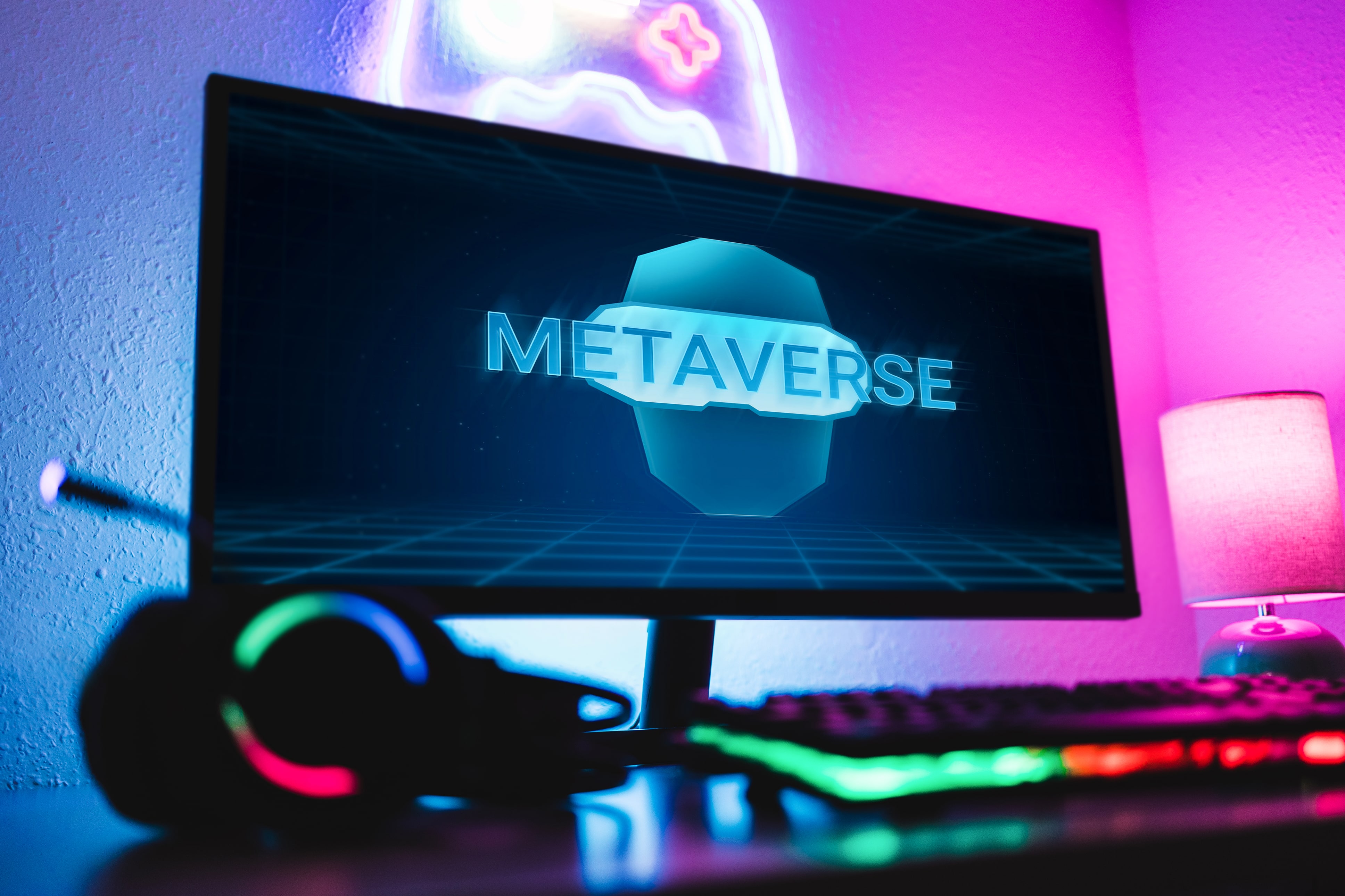 Gaming setup with neon lights featuring a monitor displaying the word 'Metaverse' in a futuristic interface, symbolizing virtual reality and digital worlds.