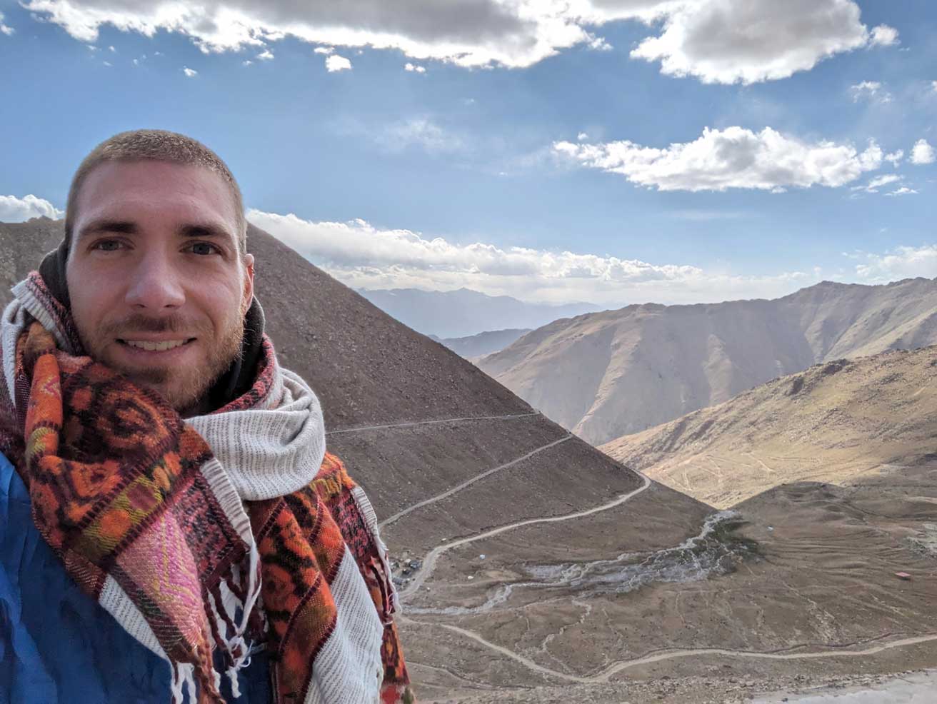 Image of Pit smiling with scarf in the mountains