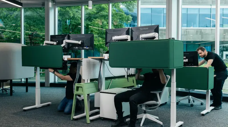 Modern office workspace with technicians setting up computer workstations and IT equipment, showcasing professional managed IT services