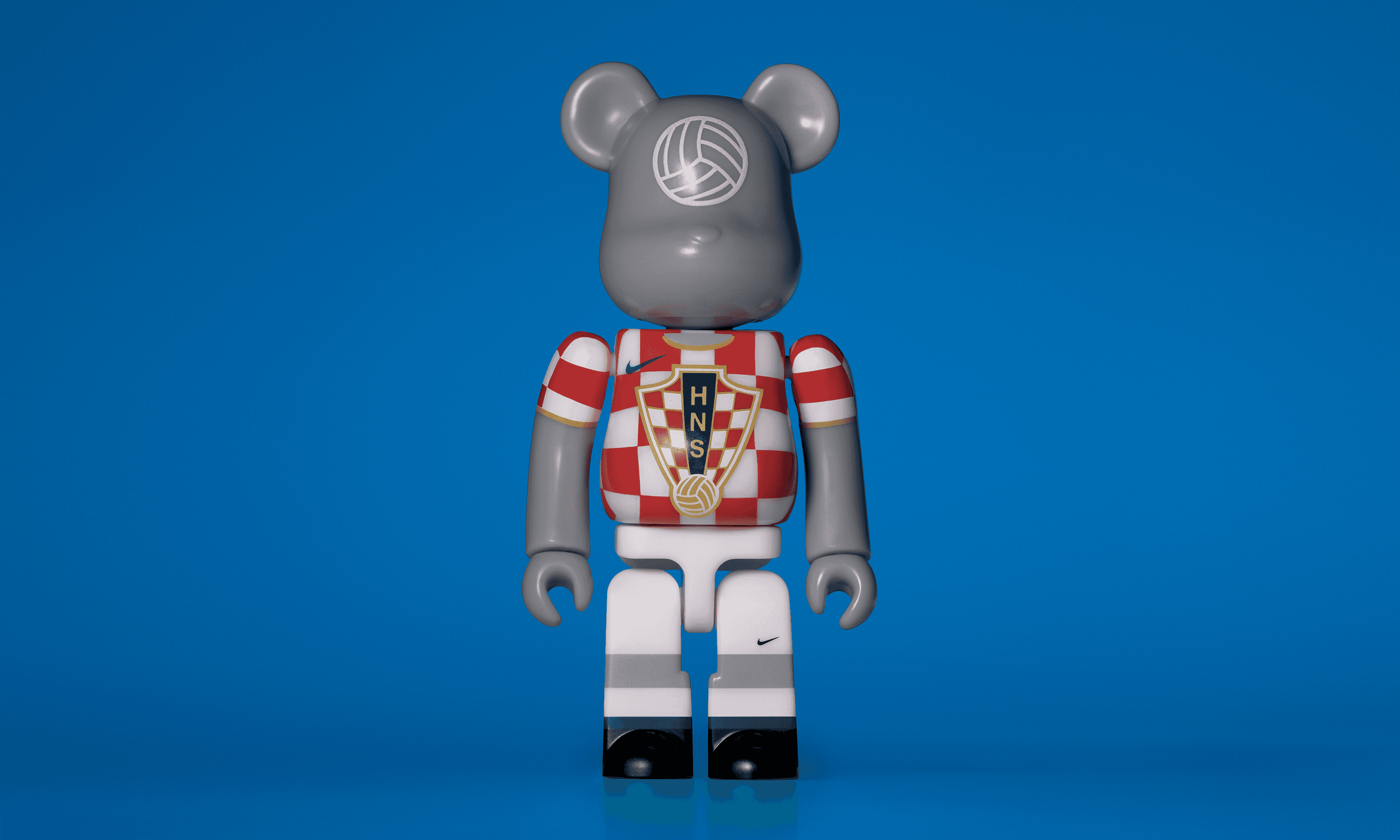 A single 3.5” tall Bre@rbrick/Nike toy created to commemorate the 2006 Croatian World Cup football team. The toy is painted to appear in the Croatian football kit and stands in the center of the frame in front of a bright yellow background. 