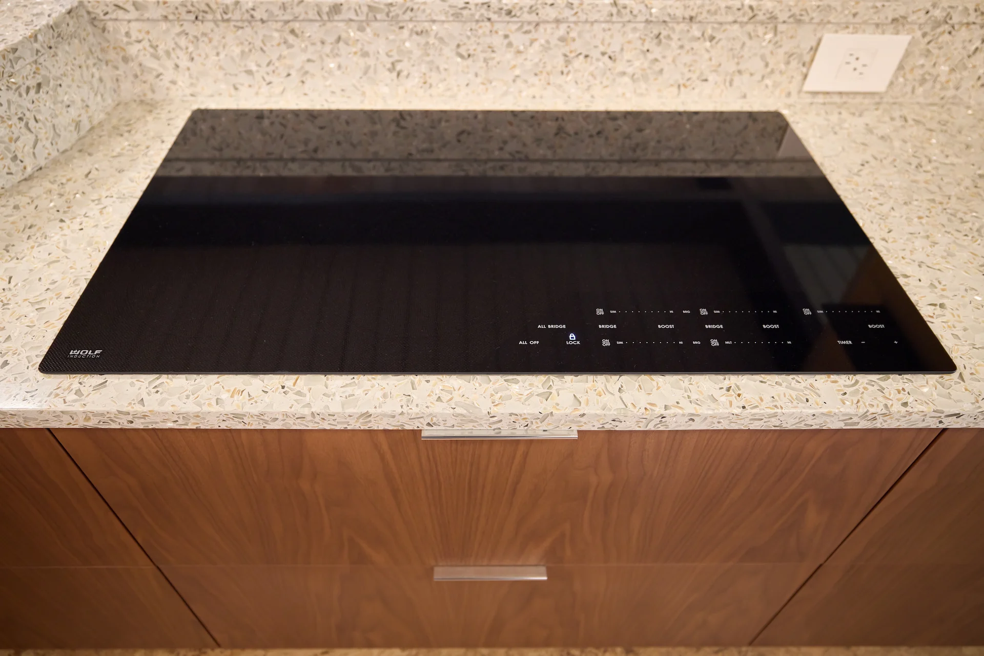 Close-up view of the Wolf induction range top in the kitchen, highlighting the modern appliances that enhance the culinary experience in this Eichler home. Photo by Todd Huge.