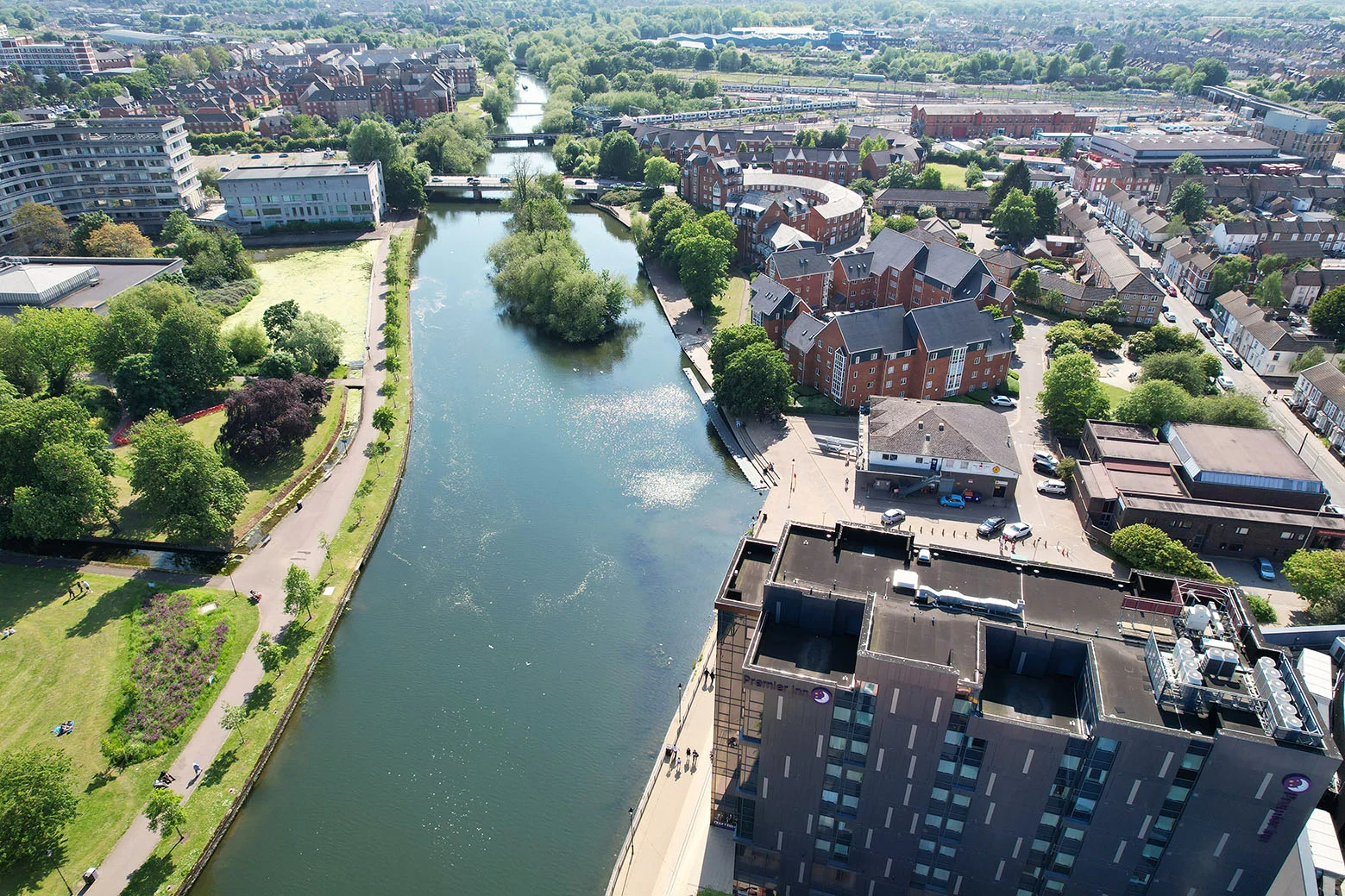 Aerial view of Bedford riverside apartments and parkland beside the river.