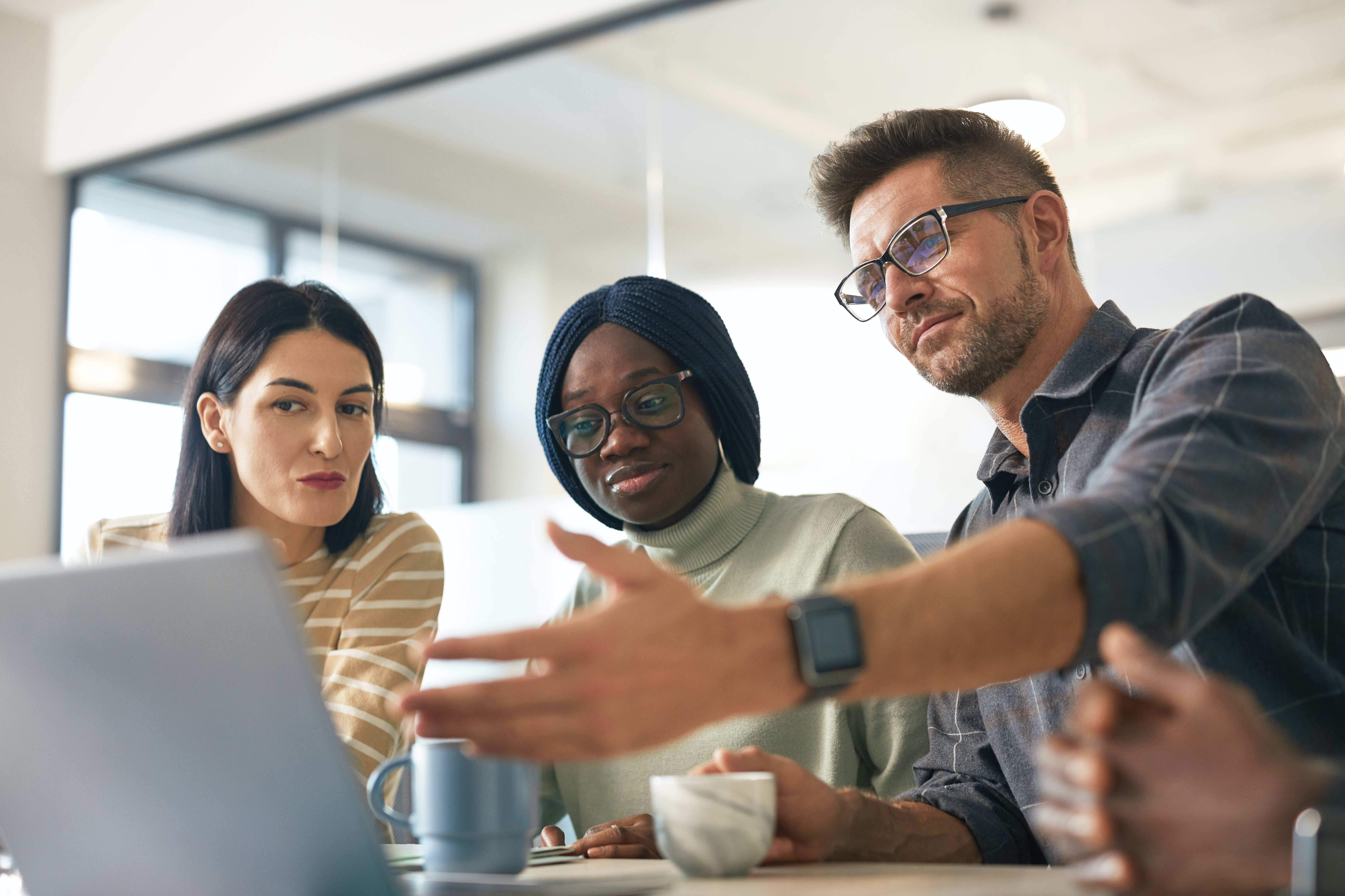 Group of people having a meeting whether to apologize for cold emailing or not