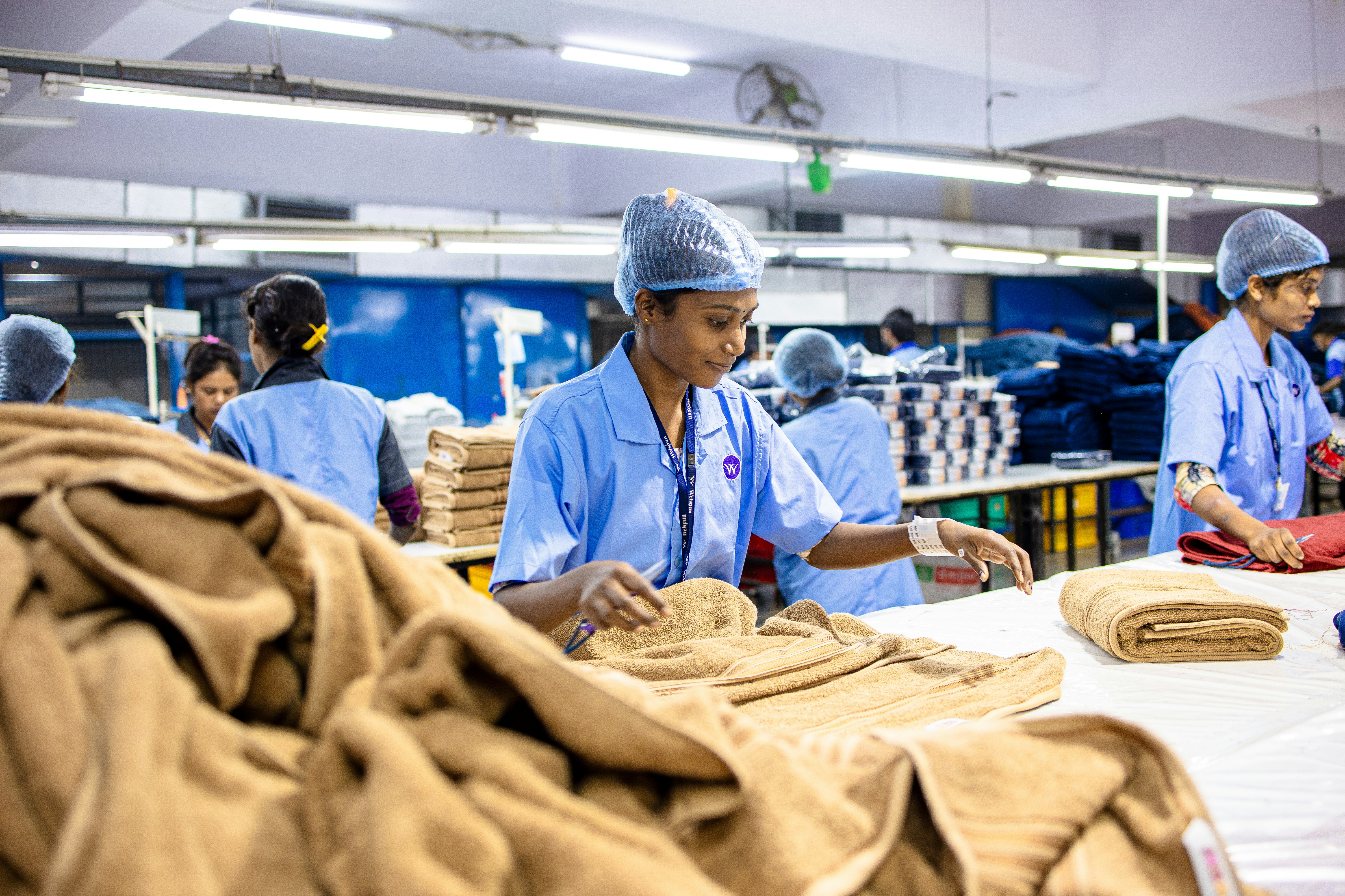 Workers are folding textiles in a factory.