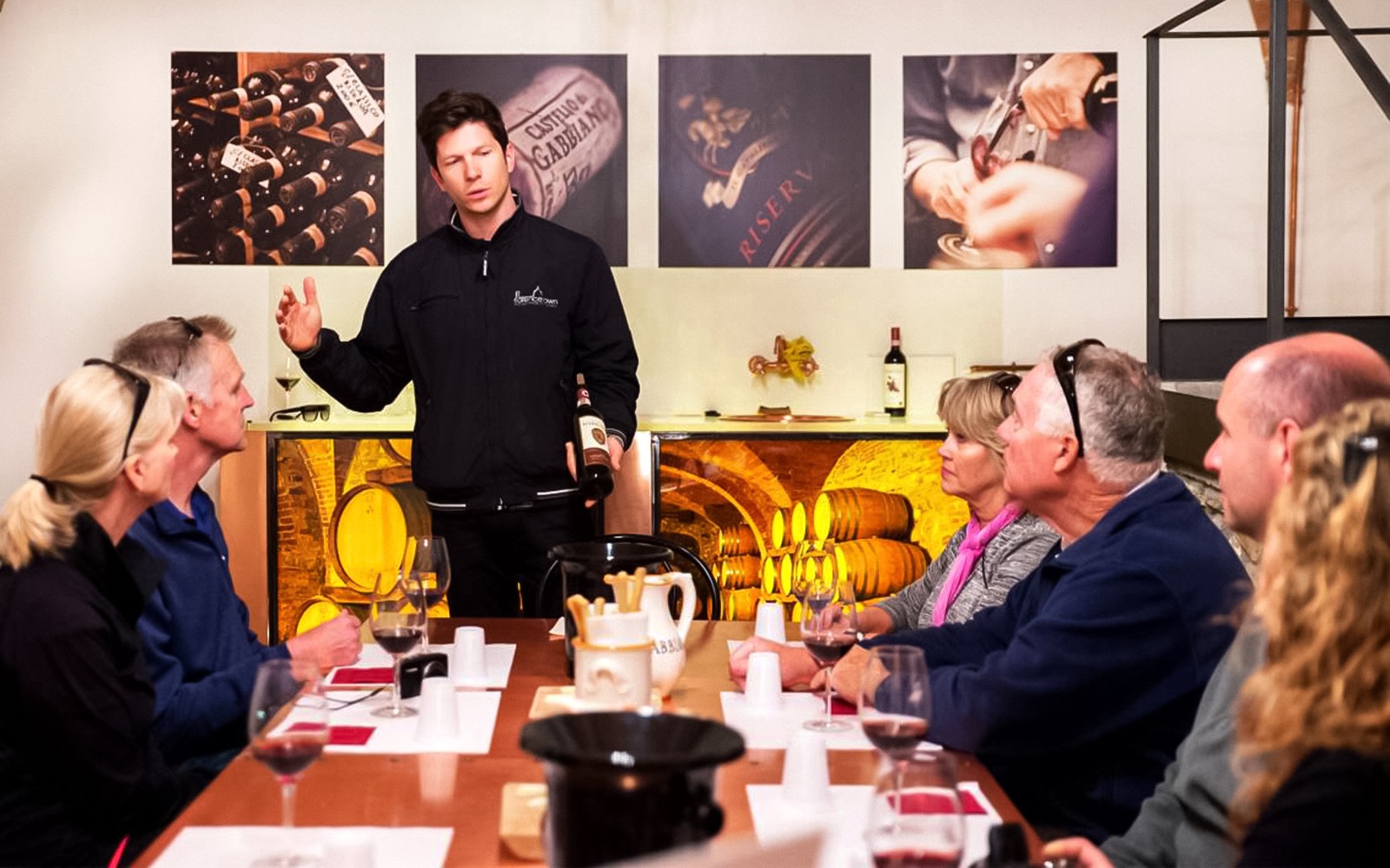 Grupa ciesząca się degustacją win w Chianti, gdzie przewodnik objaśnia szczegóły dotyczące wina.