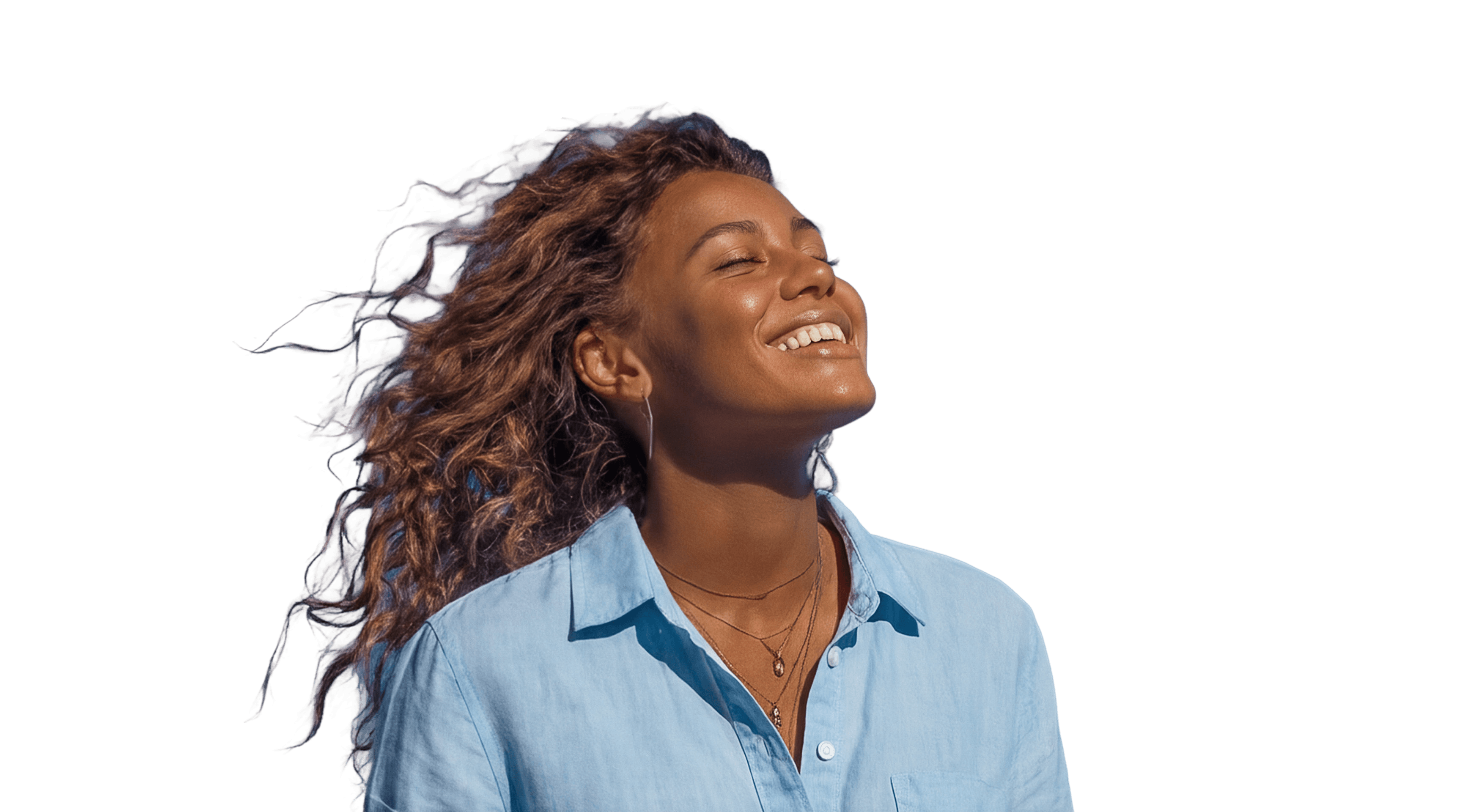 Mulher jovem negra sorrindo com o rosto voltado para o sol.