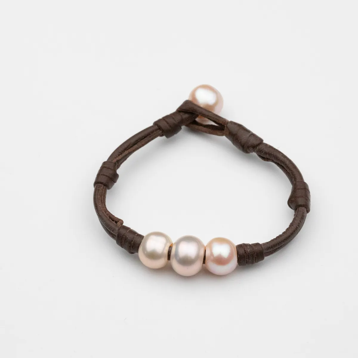 South Sea Pearl leather bracelet with four round pearls in cream and champagne tones on dark chocolate leather cord with hand-wrapped knots — Manos de Oro Saint Barth