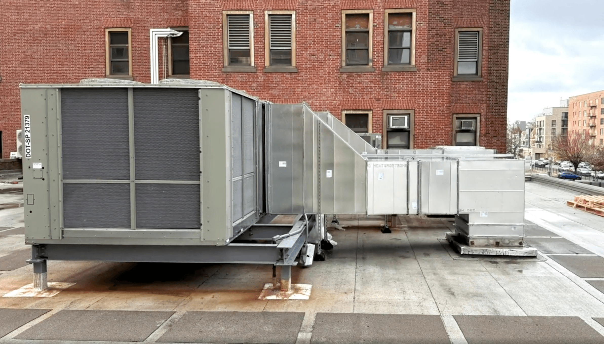 Rooftop HVAC unit installed on curb at Kings County Hospital, side view.