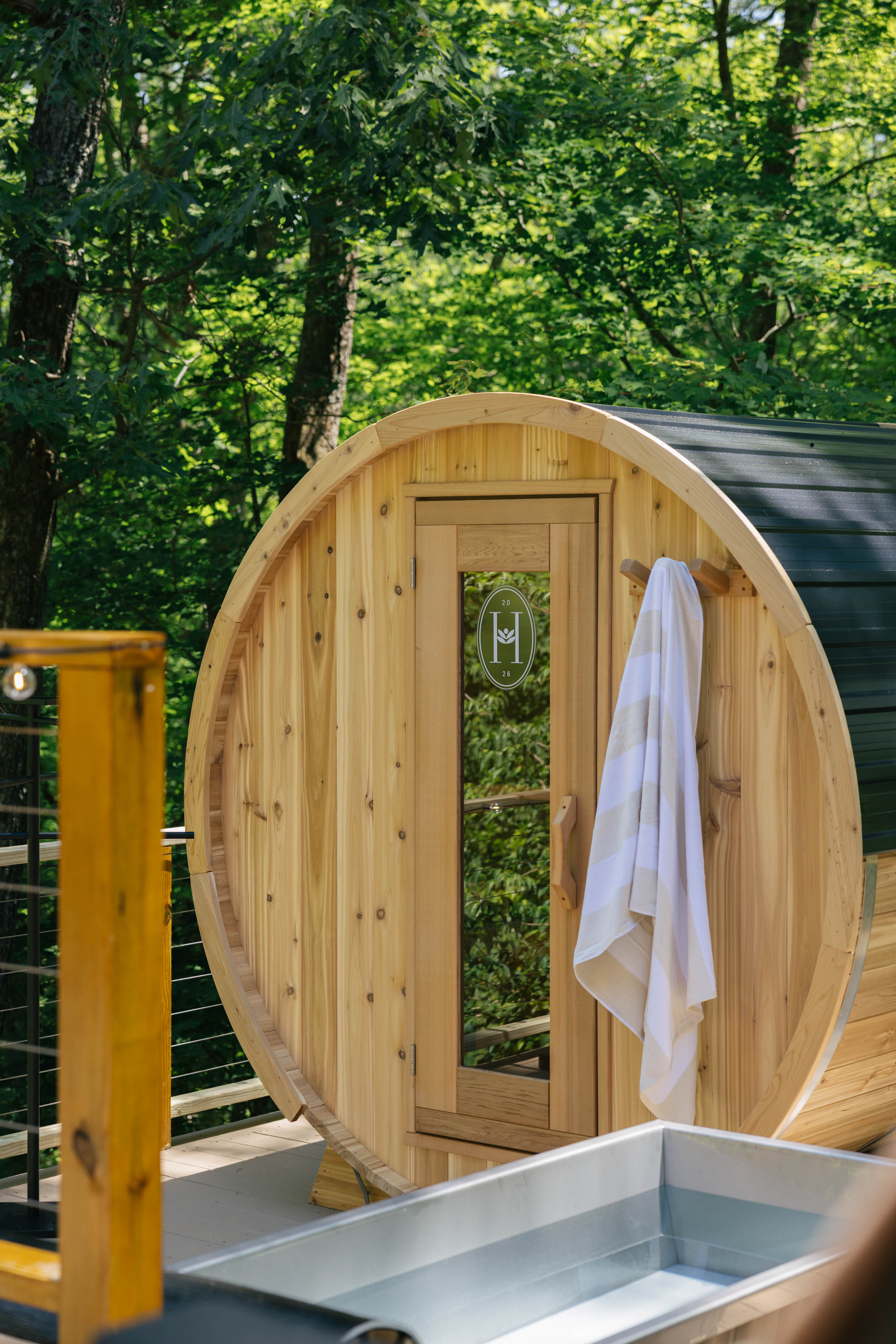 Cedar barrel sauna and cold plunge tub side by side on the deck