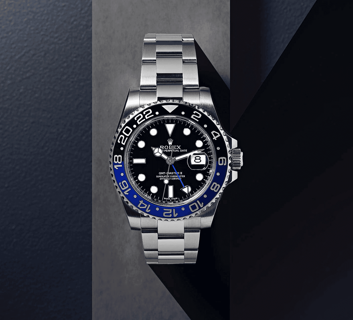 A sleek silver watch with a black face and blue accents, displayed on a dark surface.