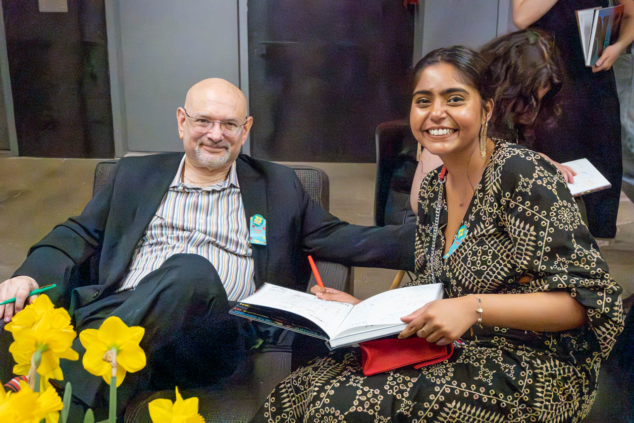 two people at a cocktail party looking at the camera