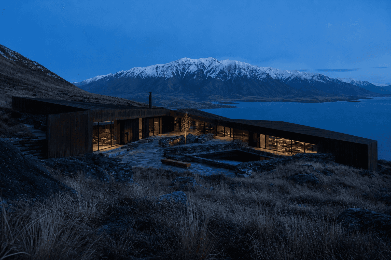 Material and atmosphere detail of Moraine Lodge, a copper and schist lodge overlooking an alpine lake in Queenstown, New Zealand