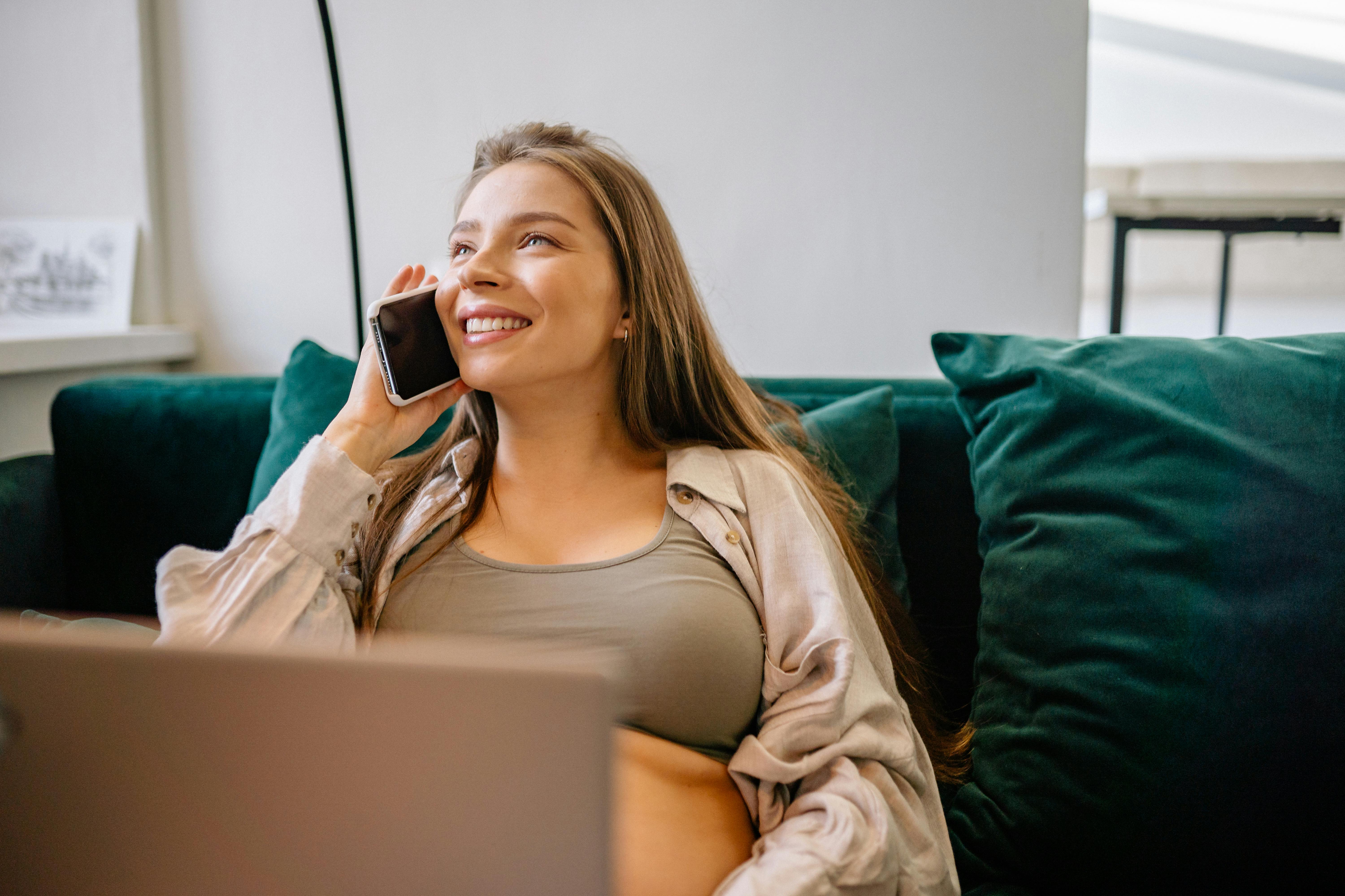 Woman on phone sitting on green couch