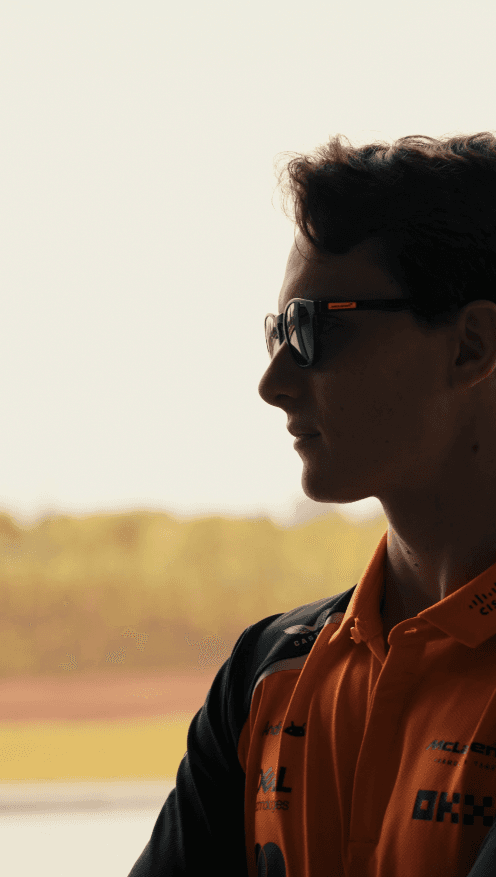 Close-up of a model holding wheat, dressed in a beige suit.