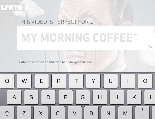 A computer keyboard is visible in the foreground, with a video player interface in the background. The video player displays a gray background with a stylized image of a person's face and text that reads “THIS VIDEO IS PERFECT FOR… MY MORNING COFFEE*” with the channel name “MY MORNING COFFEE” highlighted in gray. Below the video player, a text prompt reads “Enter an emotion or situation to name your channel.”