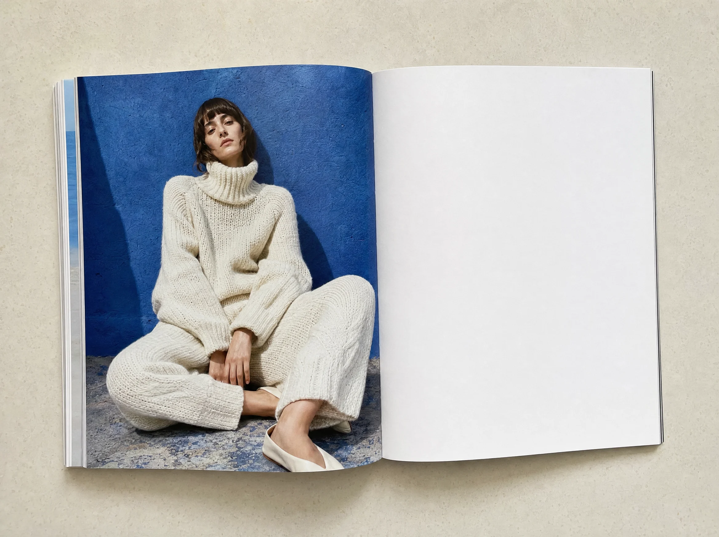 Open Blanc Studio lookbook showing a model in cream knitwear against cobalt