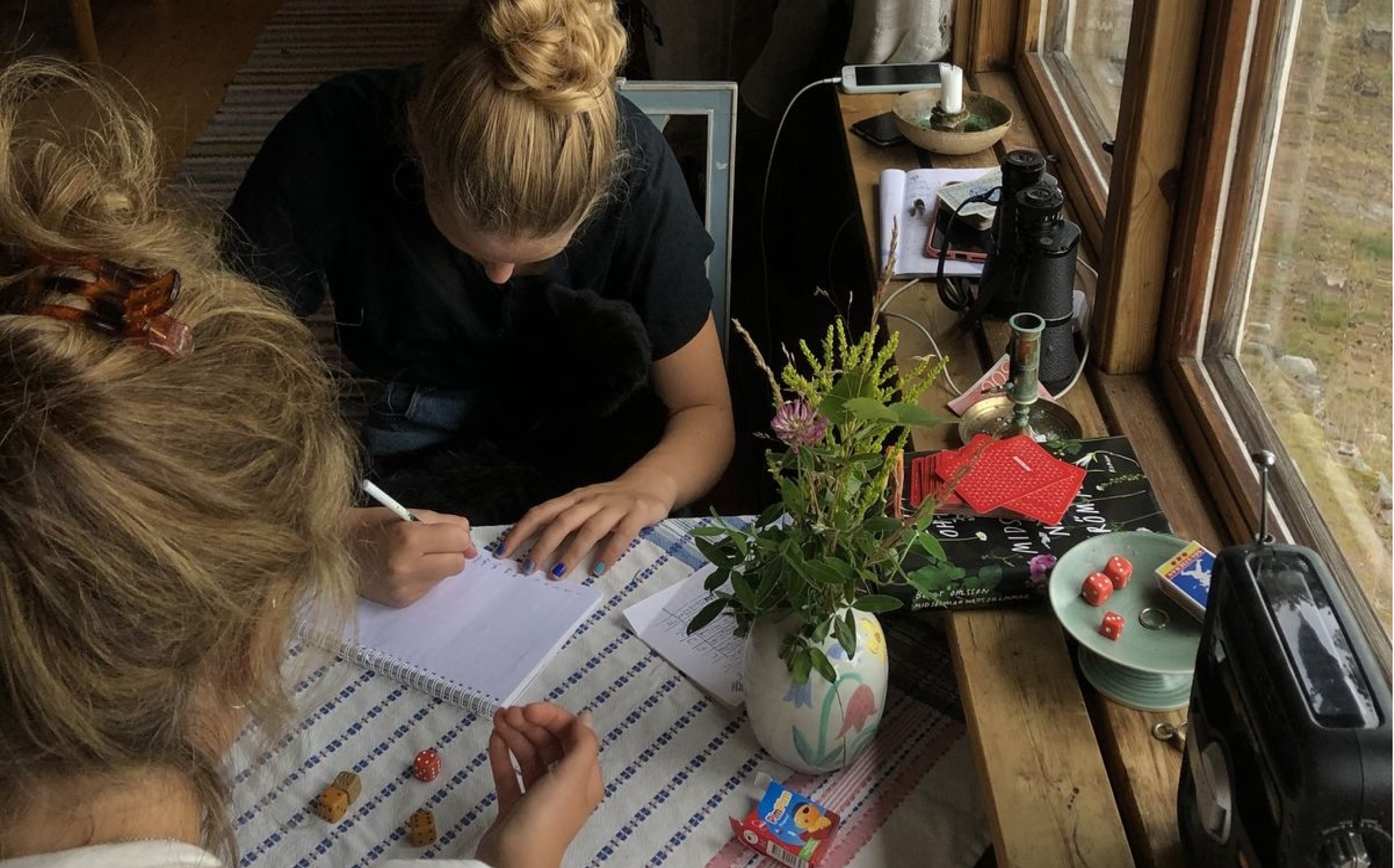 Overhead shot of two friends at a table with laptops, planners, pens, and snacks set up for an admin night.