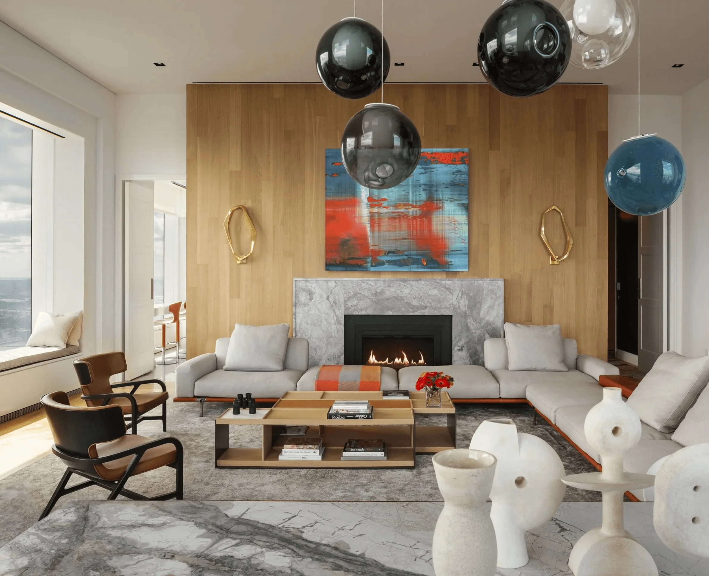 A blue-chip painting anchors this chic living room, with a fireplace and a chandelier above the dining table