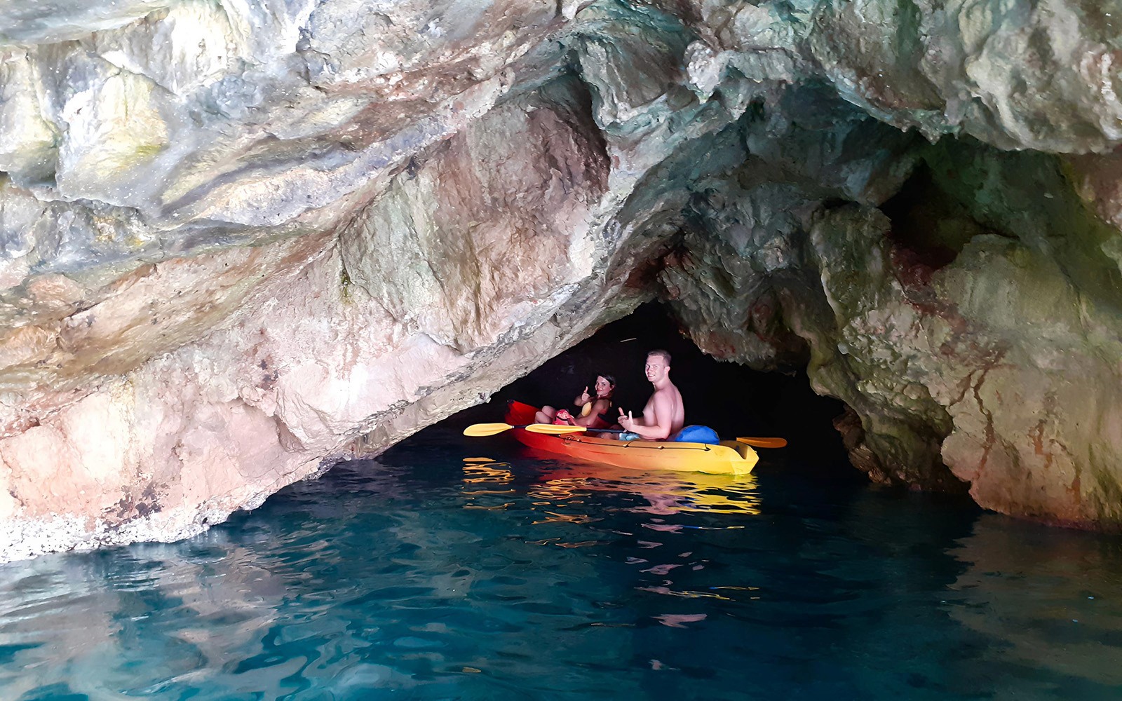 Kayakers exploring Betina Cave on a sunset tour near Old Town Walls and Lokrum Island.