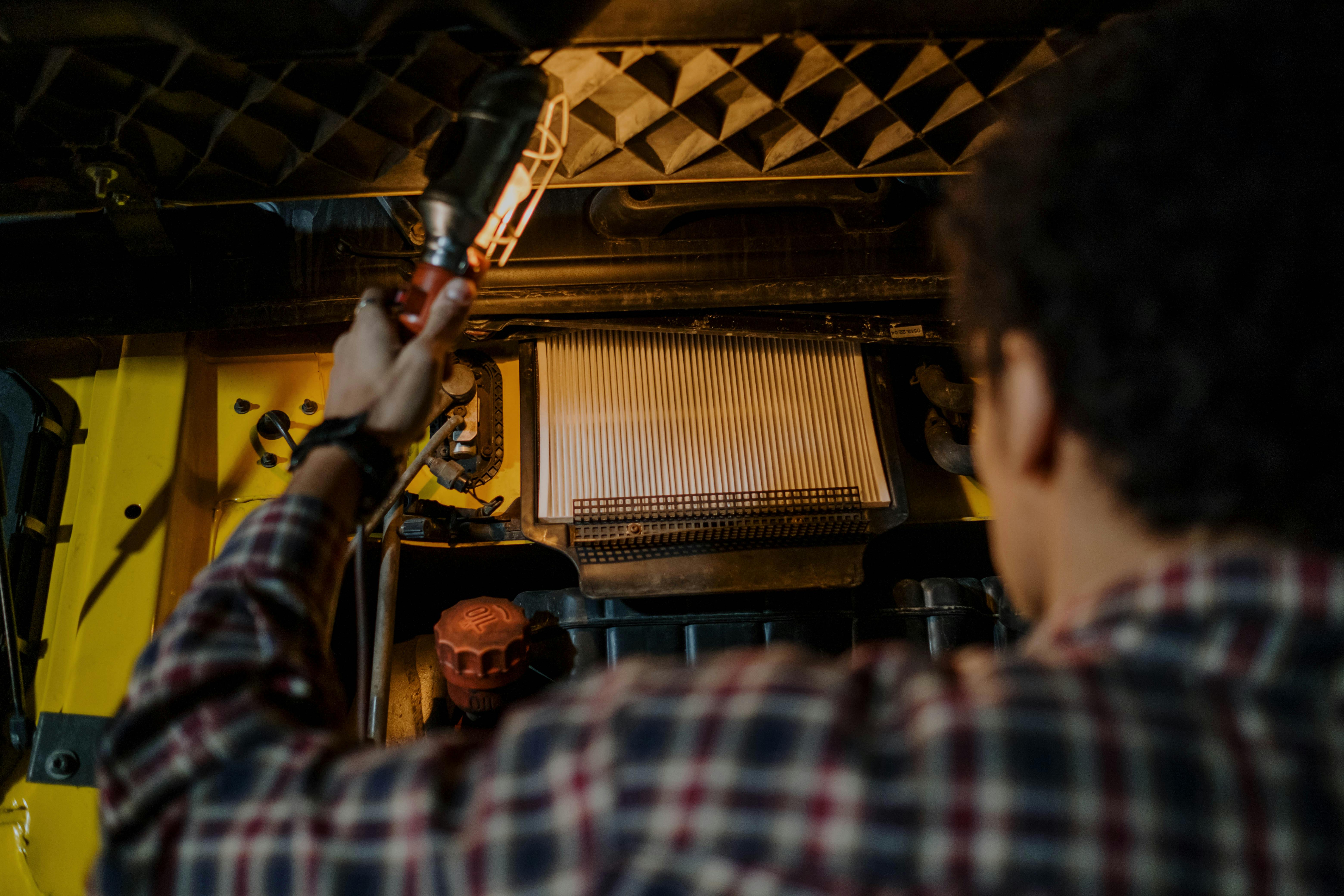 Mechanic holding a light and inspecting a truck