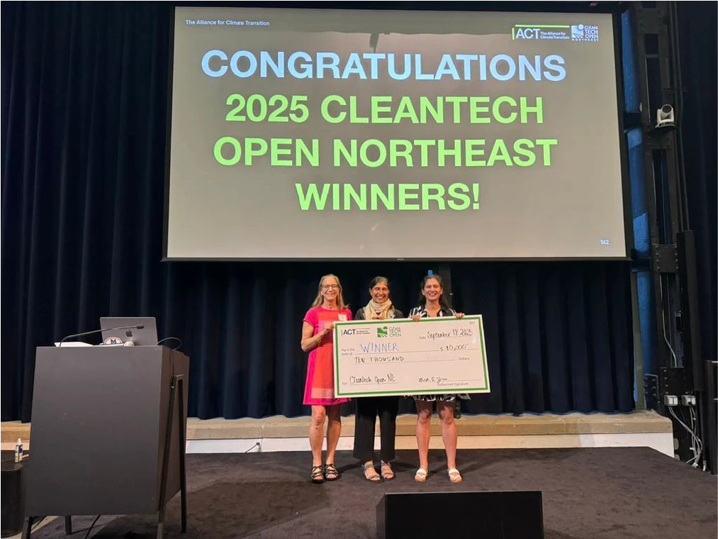 Co-founders accepting an award check, showing company milestone achievement.