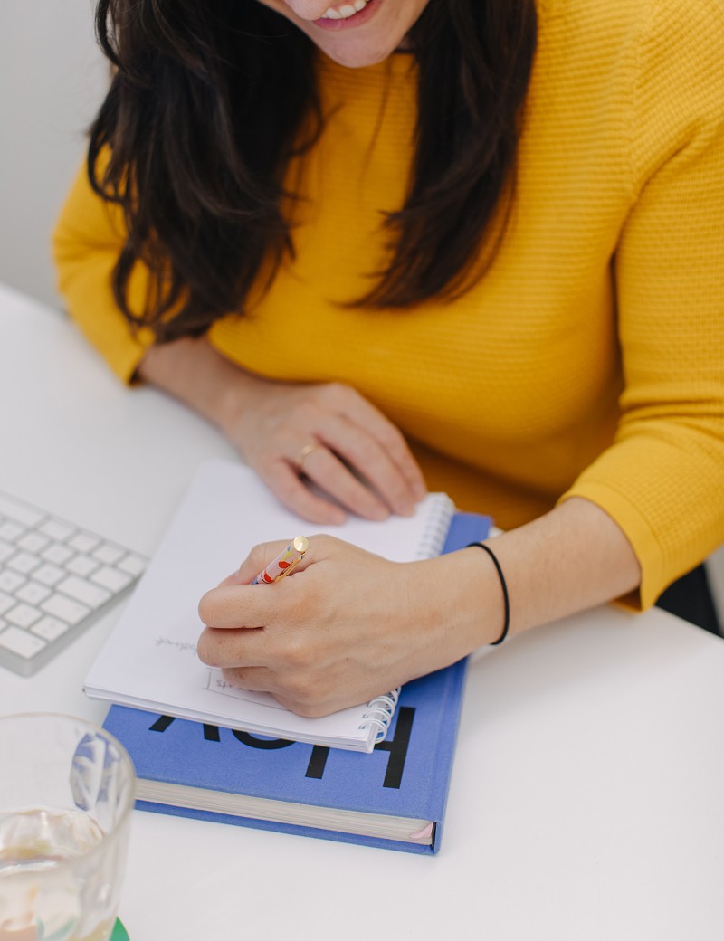 A woman taking notes at her desk